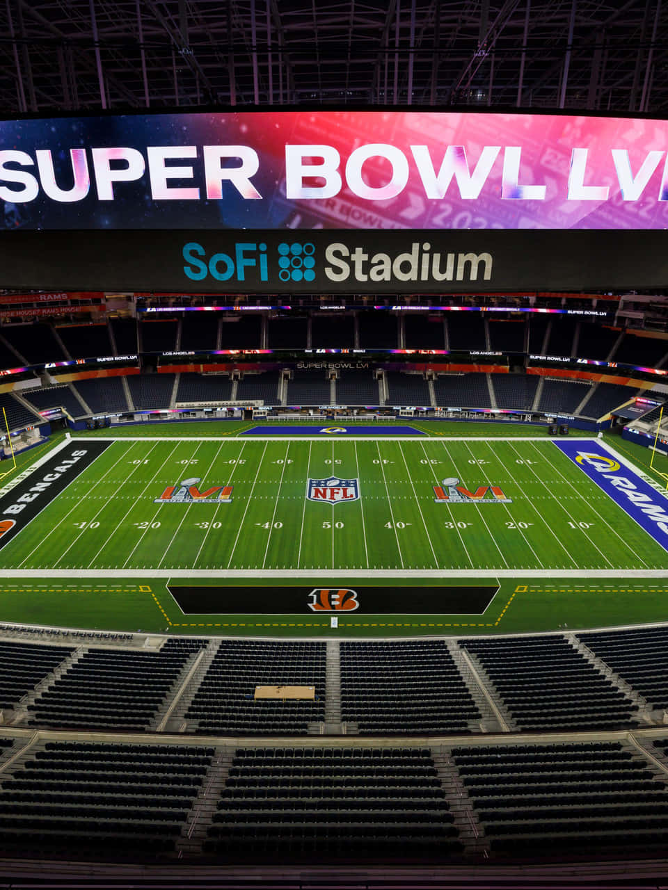 Sofi Stadium 桌布 壁紙 — 夜晚空無一人的SoFi體育場鳥瞰圖，帶有發光的Super Bowl LVII標誌和充滿活力的綠色場地。