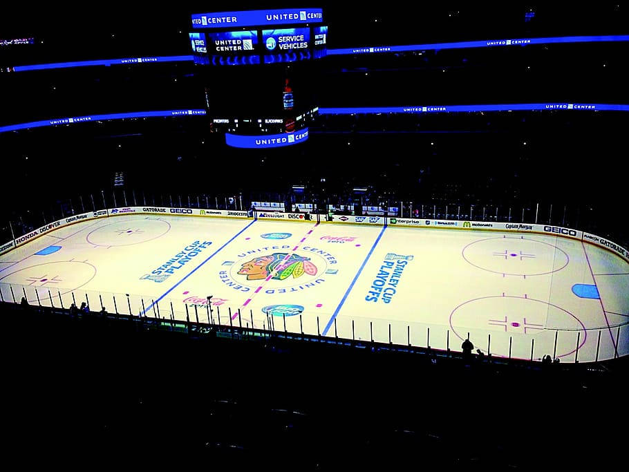 Blackhawks 桌布 壁紙 — 夜晚空無一人的冰球場地鳥瞰圖，在明亮的藍色場館燈光下，帶有「Stanley Cup Playoffs」品牌標誌。