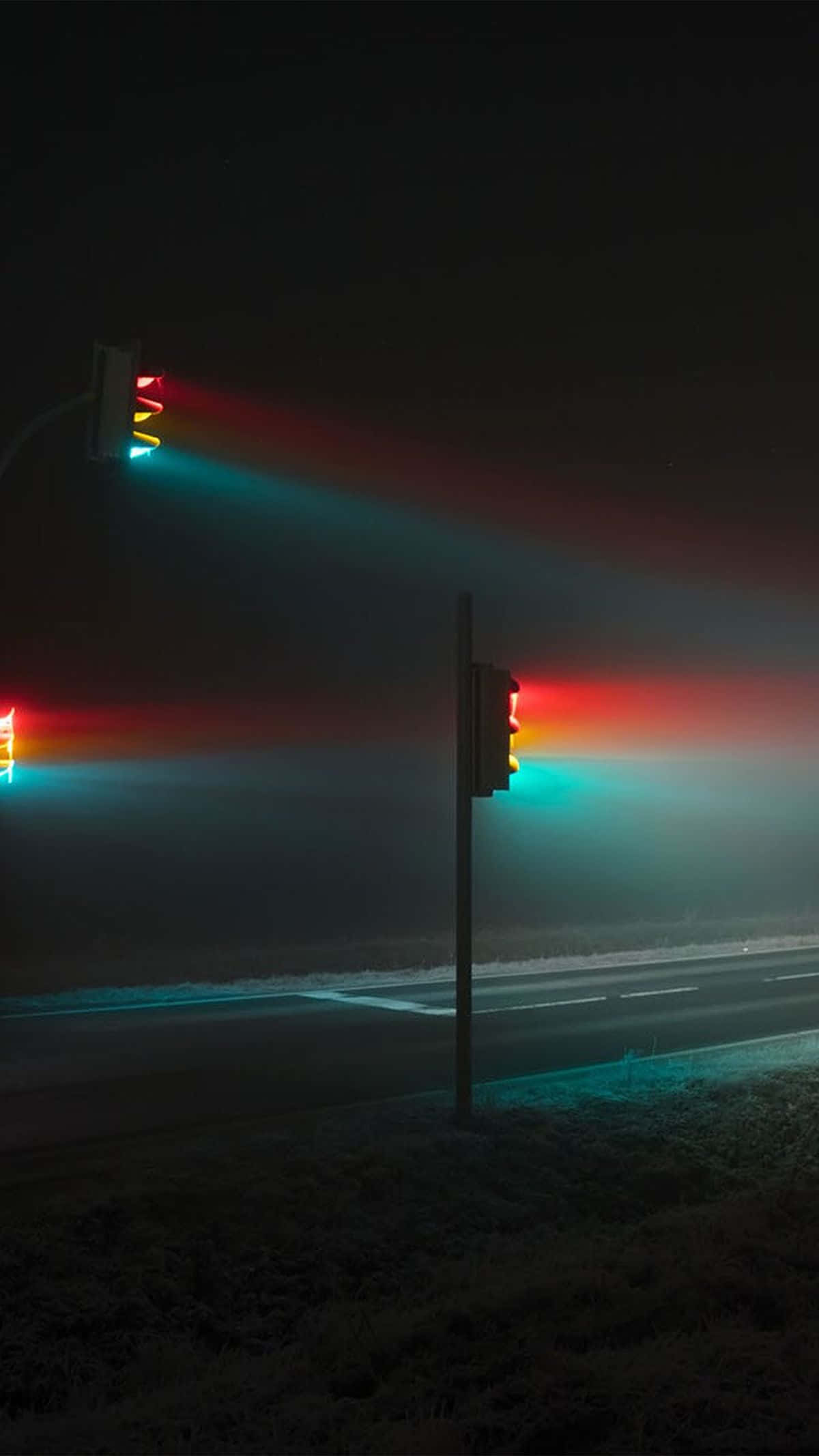 OLED 桌布 壁紙 — 夜晚結霜的路邊，發光的交通燈透過霧氣投射出鮮豔的紅色和青綠色光束。