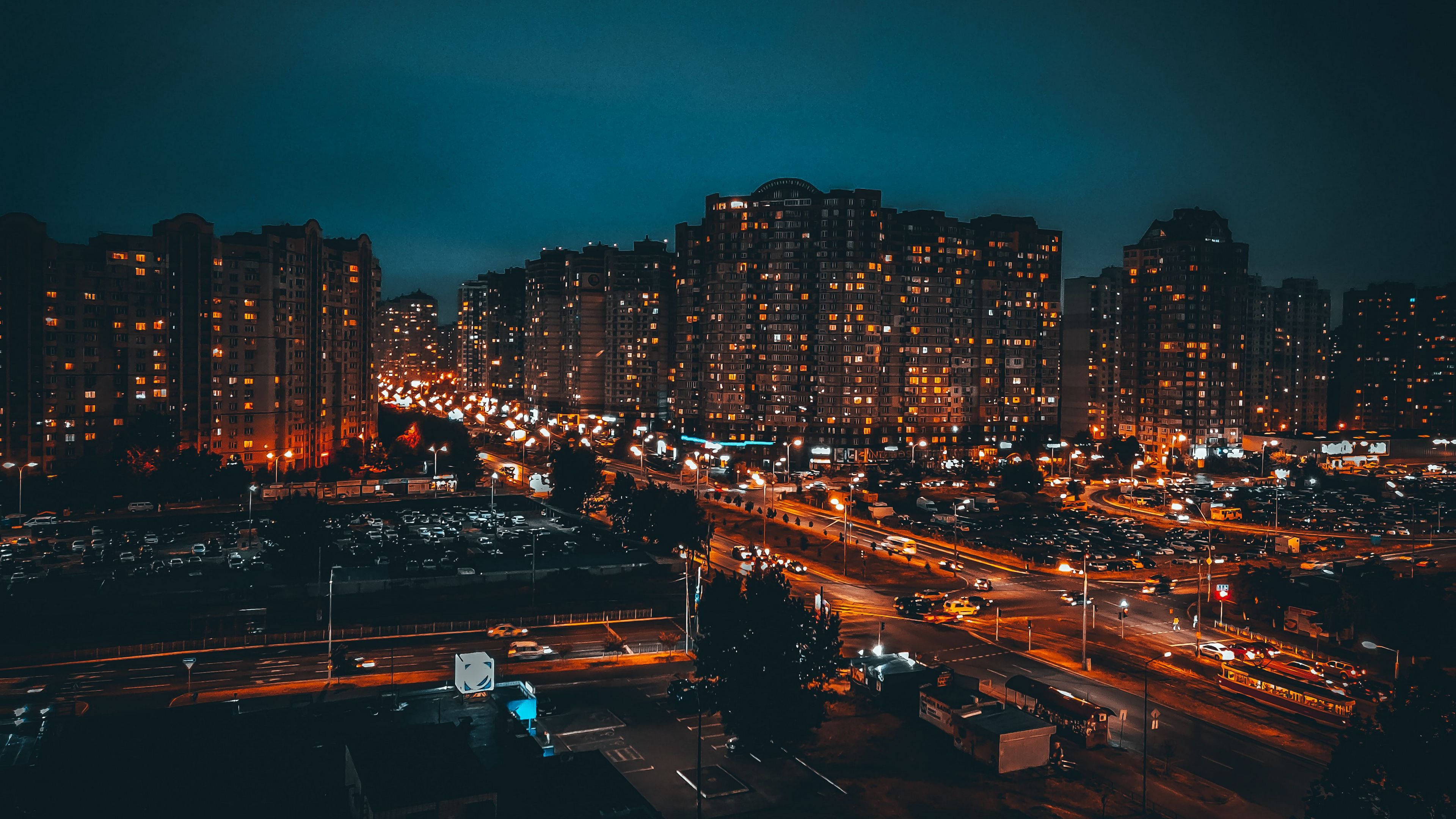 桌布 壁紙 — 夜晚繁忙城市的鳥瞰圖，閃爍的窗戶和汽車燈光劃過街道。