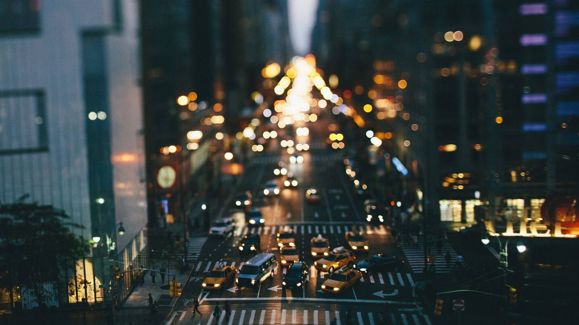 New York 桌布 壁紙 — 夜晚繁忙的城市街道，汽車和建築物的模糊燈光營造出夢幻般的散景效果。