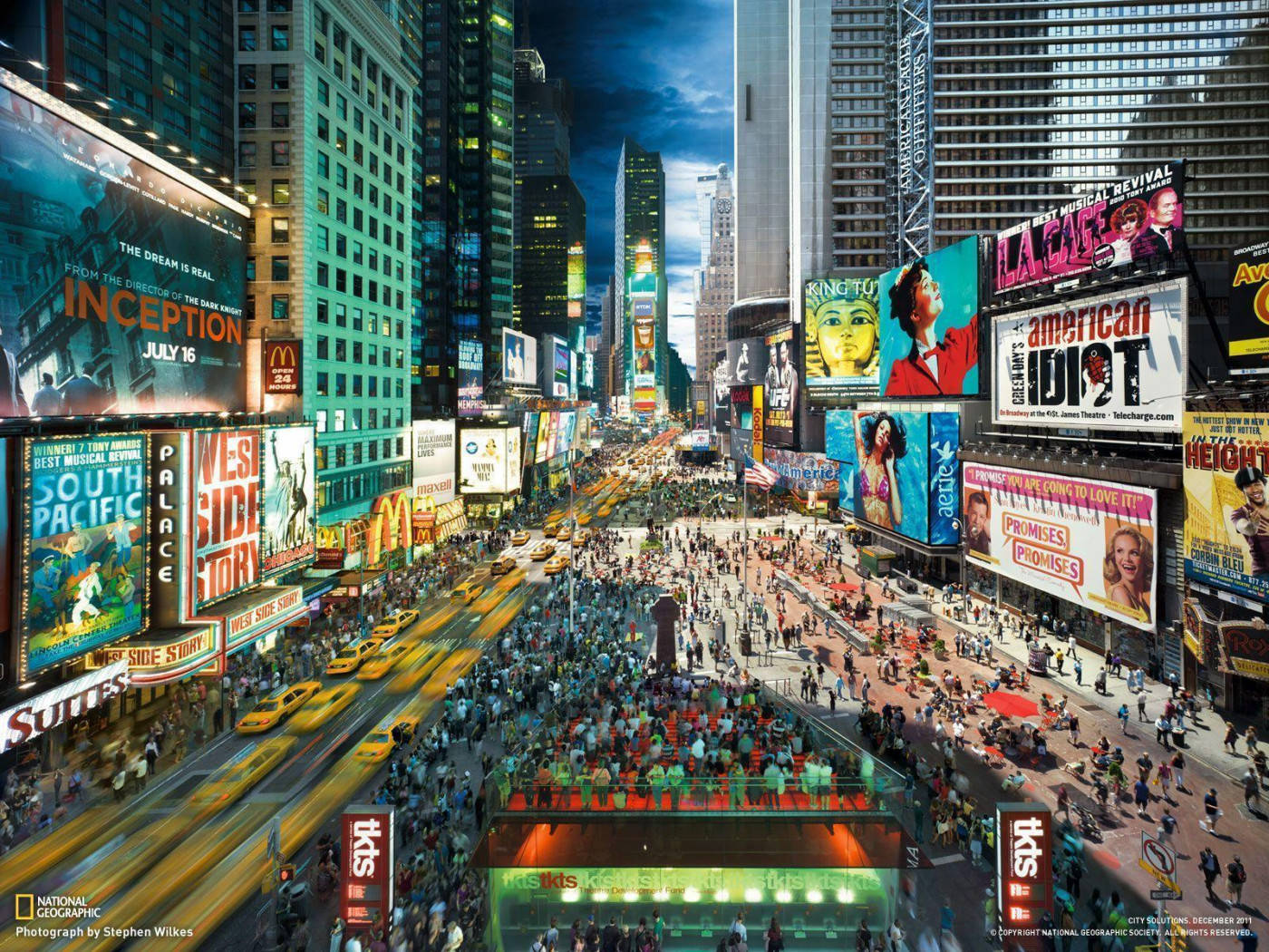 Broadway 桌布 壁紙 — 夜晚繁忙的時代廣場，高聳的建築物在霓虹燈牌下閃耀，黃色的士穿梭而過。