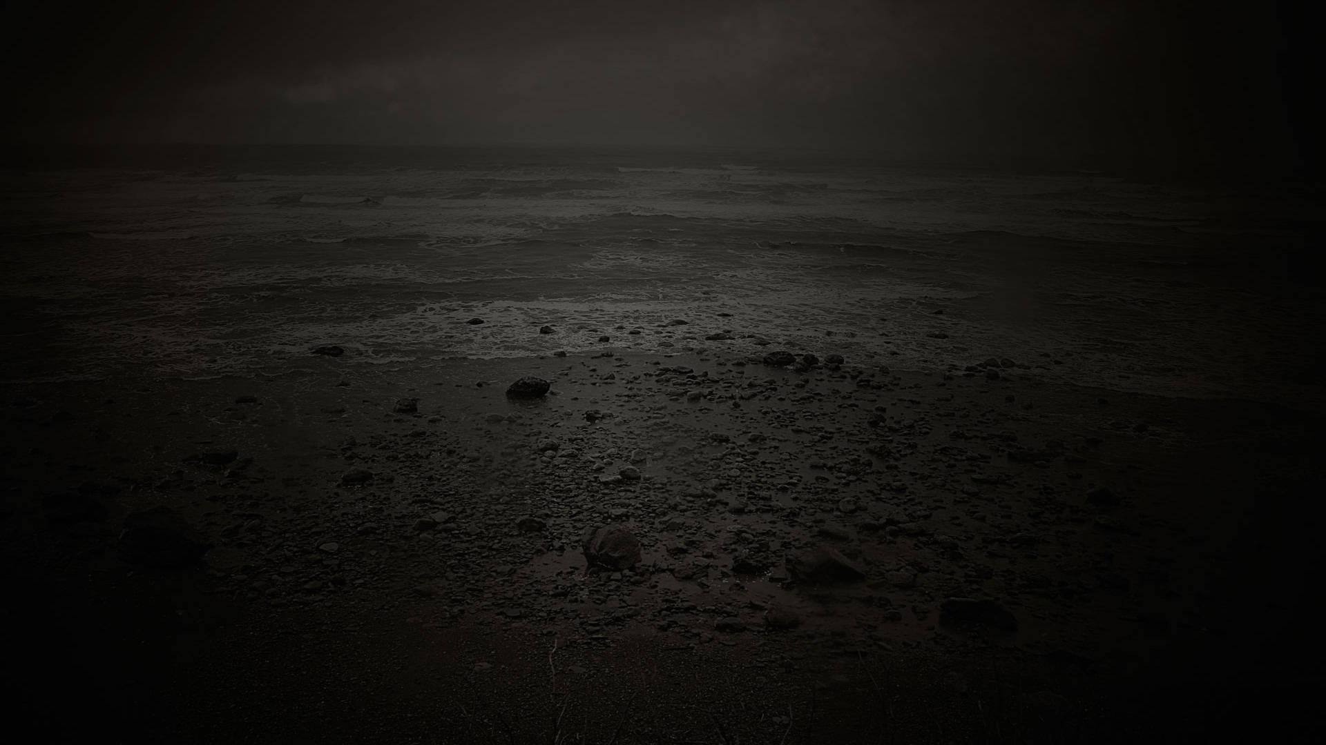 憂鬱 桌布 壁紙 — 夜晚荒涼陰暗的海灘，霧氣瀰漫的波浪拍打岩石海岸，天空陰沉。
