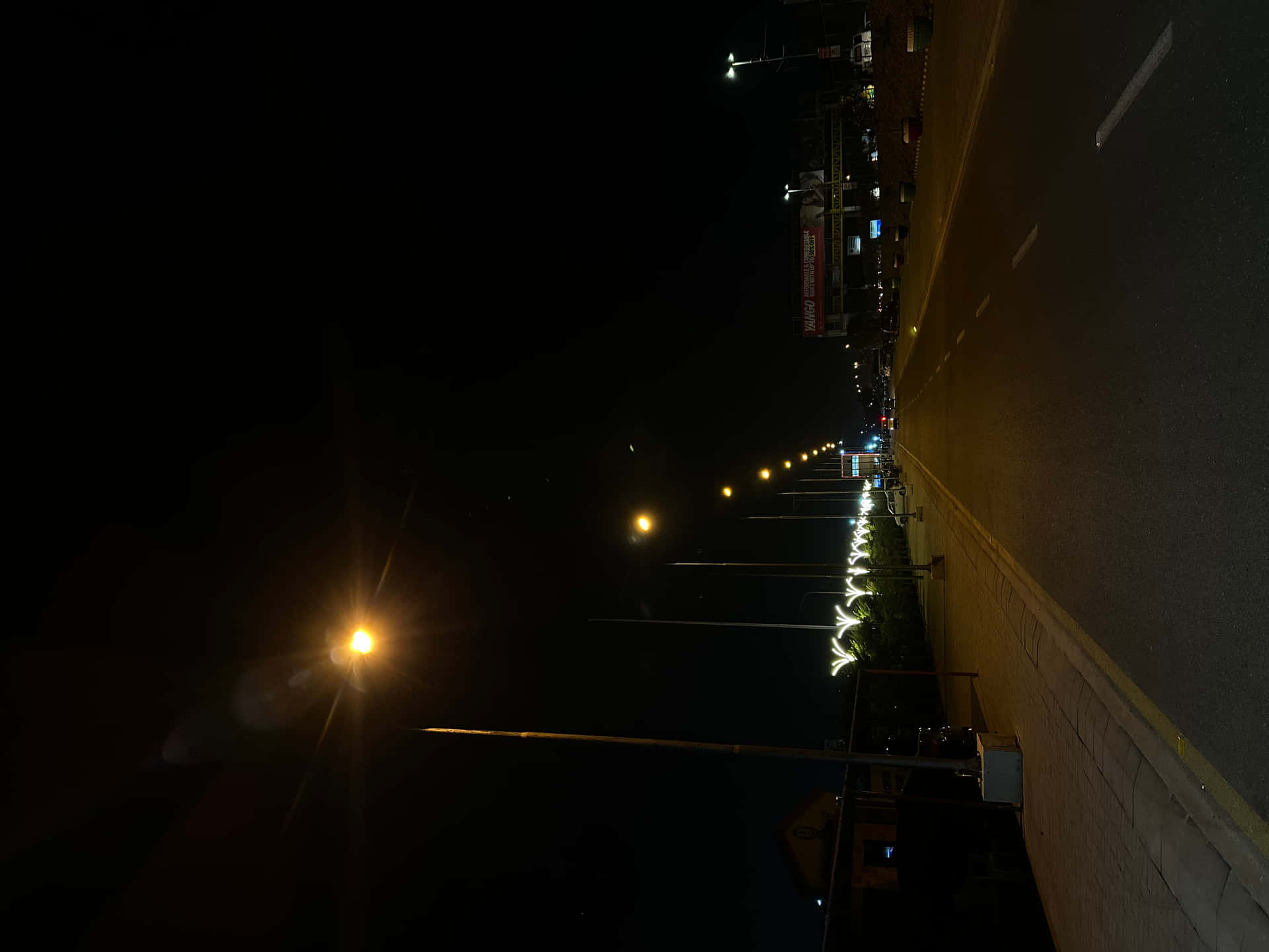 Empty roads,Sad Music and beautiful Memories with her 壁紙 — 夜晚街道景觀，發光的街燈在瀝青道路和人行道上投射出溫暖的黃光。