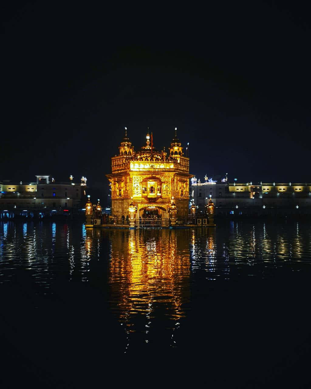 Golden Temple 桌布 壁紙 — 夜晚被照亮的金色寺廟在黑暗天空下平靜的水面上燦爛地倒映。