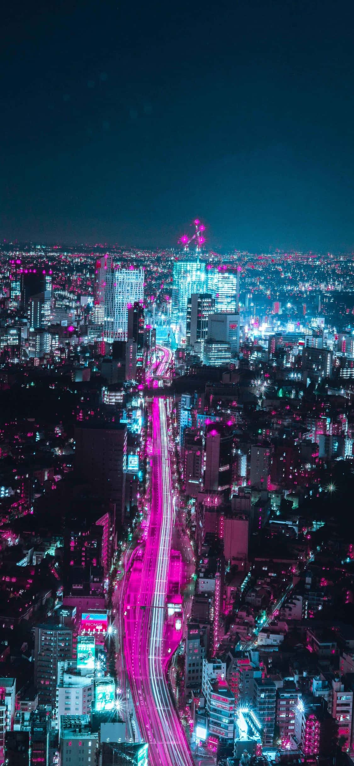 Japanese iPhone 桌布 壁紙 — 夜晚被霓虹燈浸染的城市景觀，閃爍的粉紅和藍色燈光照亮高聳的建築物和充滿活力的高速公路。