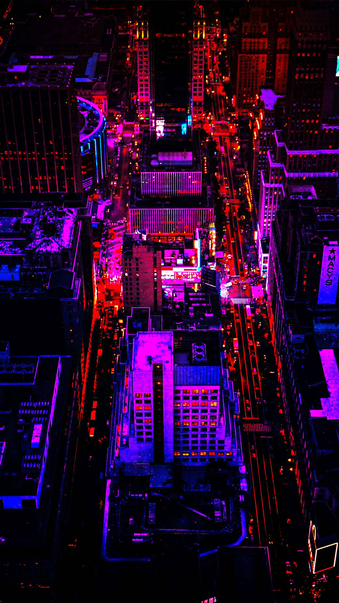 手機 桌布 壁紙 — 夜晚被霓虹燈浸染的城市景觀鳥瞰圖，充滿活力的紫色和紅色燈光照亮了高聳的建築物和街道。