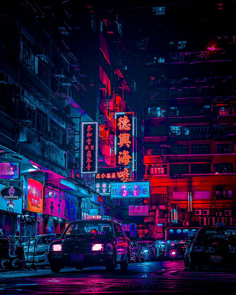 動漫風格 桌布 壁紙 — 夜晚被霓虹燈淹沒的城市小巷，發光的招牌映照在濕漉漉的人行道上，汽車沿著狹窄的街道停放。