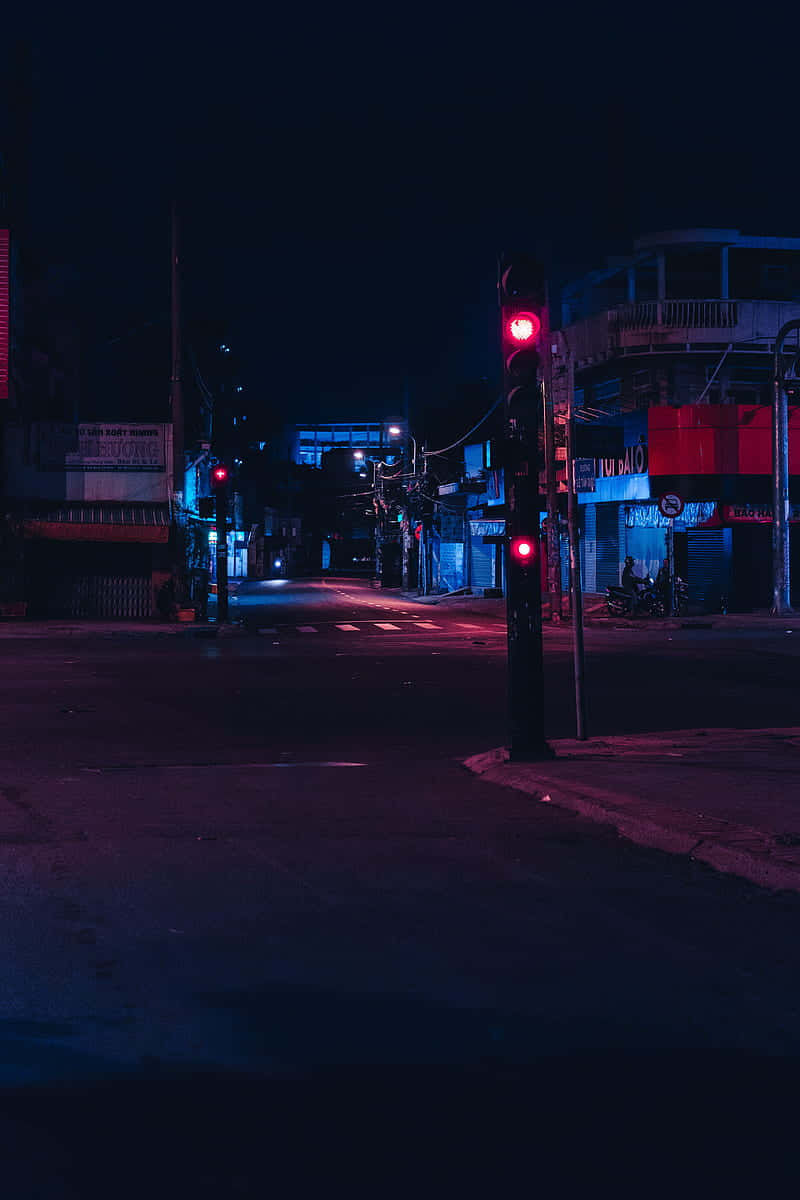 Road 桌布 壁紙 — 夜晚被霓虹燈淹沒的城市街道，紅色交通燈在潮濕的路面上投射出超現實的光芒。