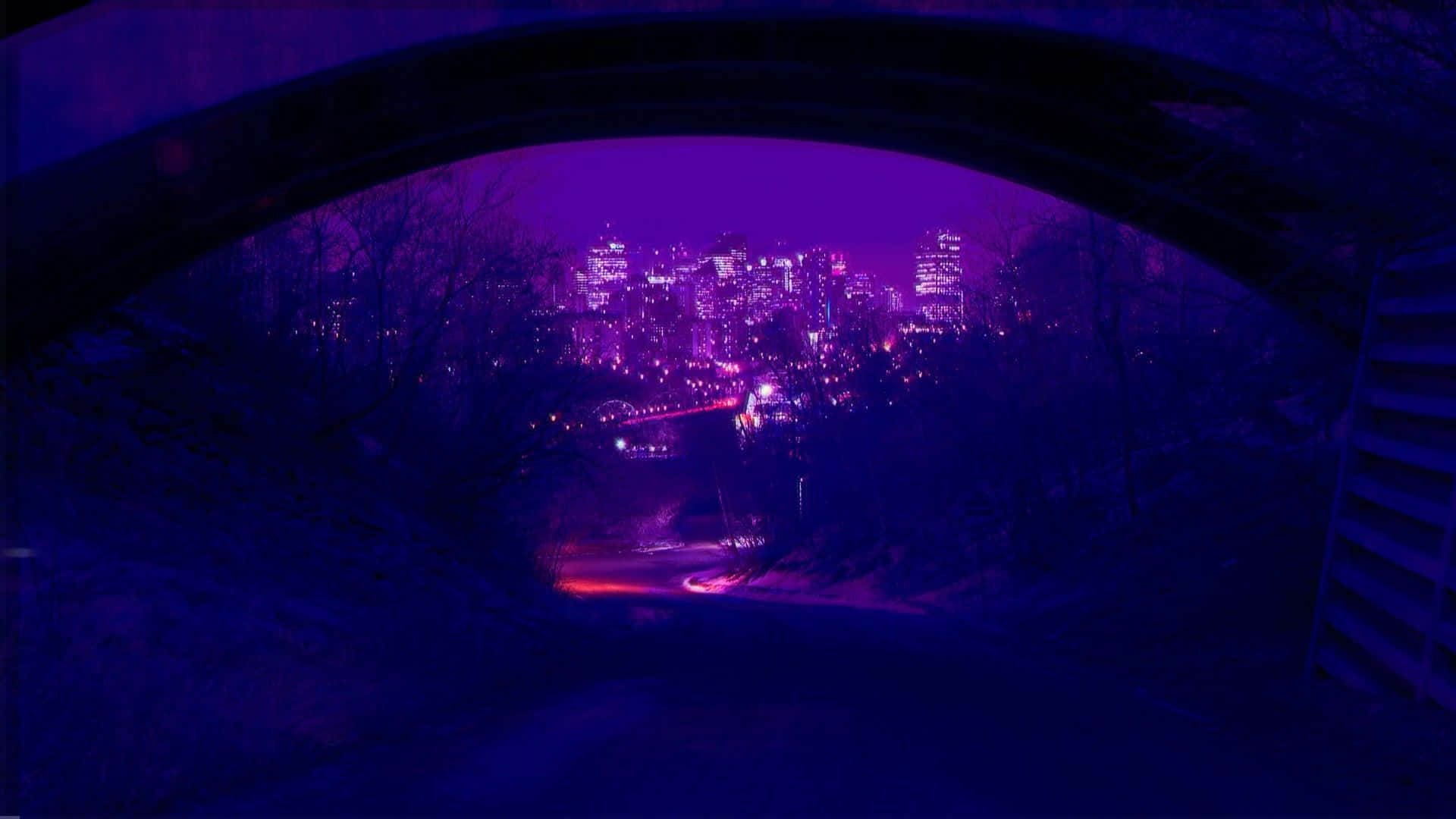 Grunge Aesthetic Mac 桌布 壁紙 — 夜晚透過黑暗石拱門看到的城市天際線，閃爍著紫色和粉紅色的燈光。