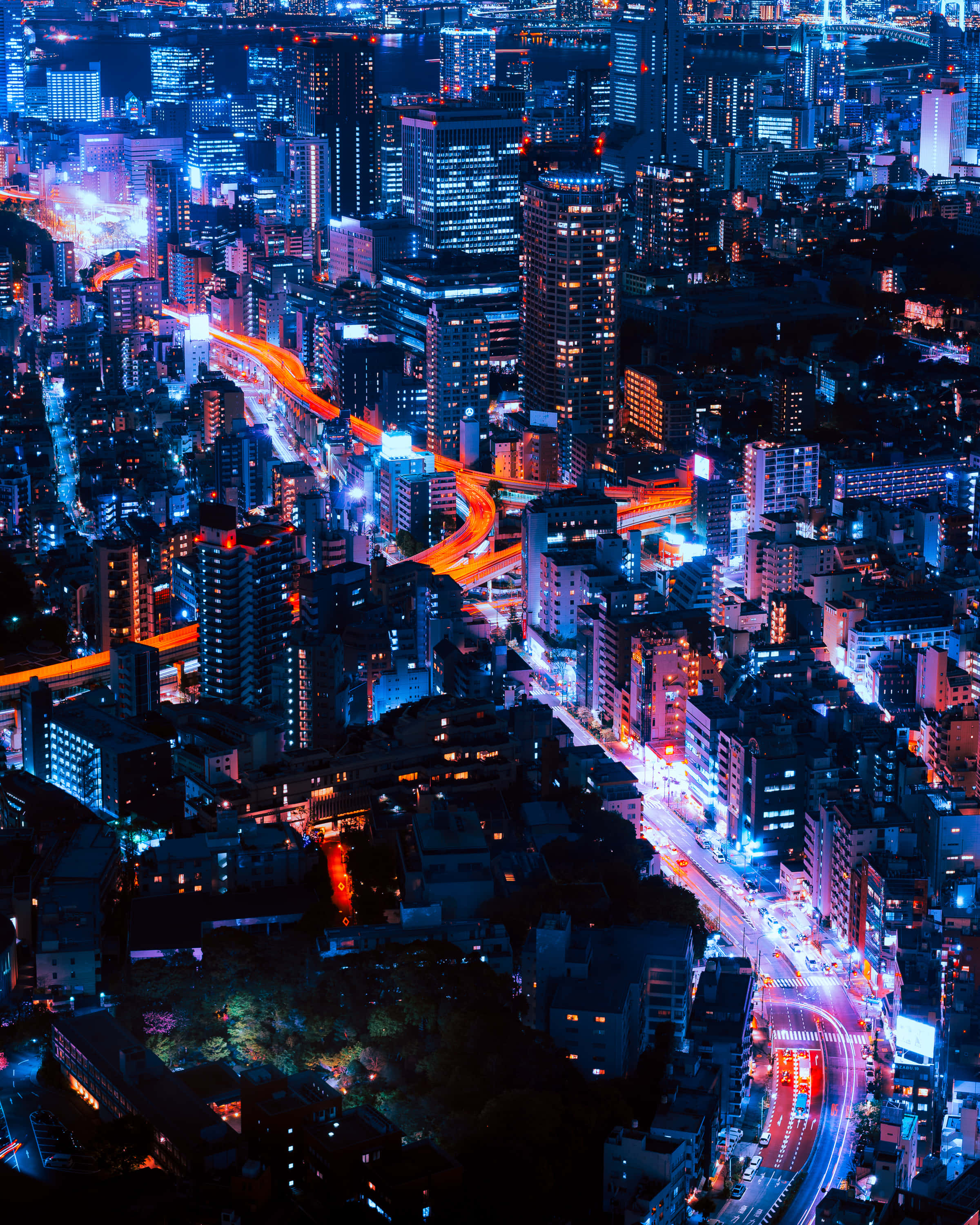 lights 桌布 壁紙 — 夜晚霓虹燈照亮城市天際線的鳥瞰圖，有發光的藍色摩天大樓和橙色交通燈流線。