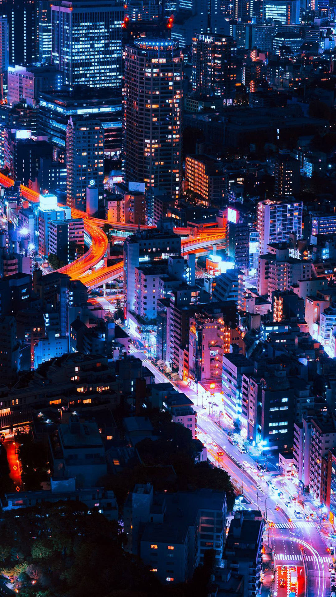 Aesthetic iPhone Xr 桌布 壁紙 — 夜晚霓虹燈照亮的天際線鳥瞰圖，發光的摩天大樓和流動的交通燈光。