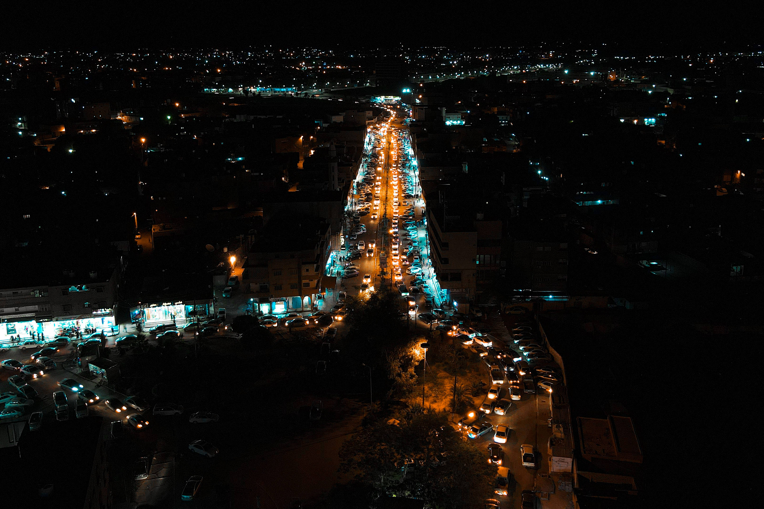 Libya 桌布 壁紙 — 夜晚鳥瞰繁華城市街道，車頭燈和街燈在黑暗建築物映襯下閃閃發光。