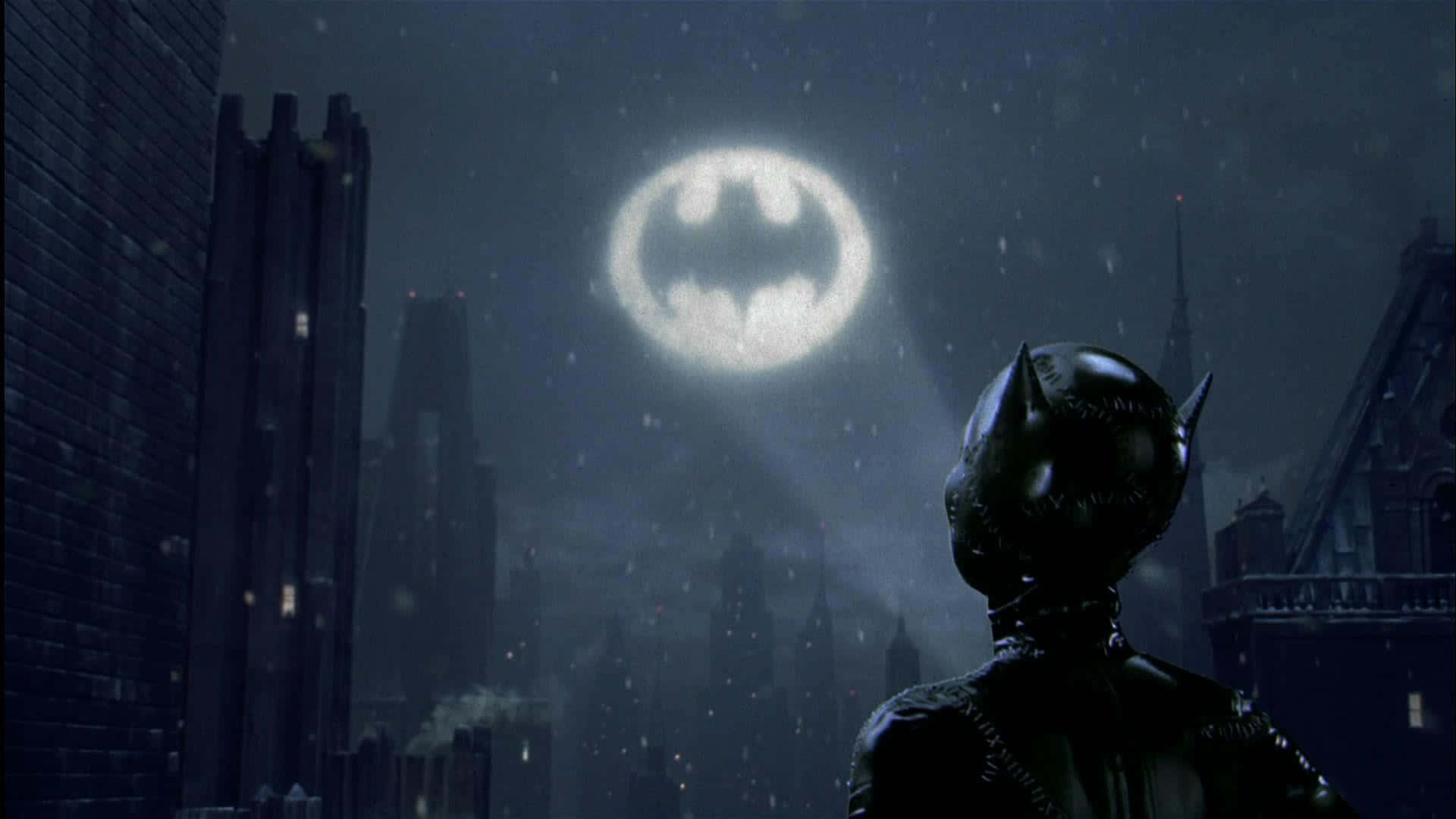 Bat Signal 桌布 壁紙 — 夜晚黑暗濕滑的雨夜城市景觀，天空中有發光的蝙蝠標誌，一個戴面具的人物以剪影站立。