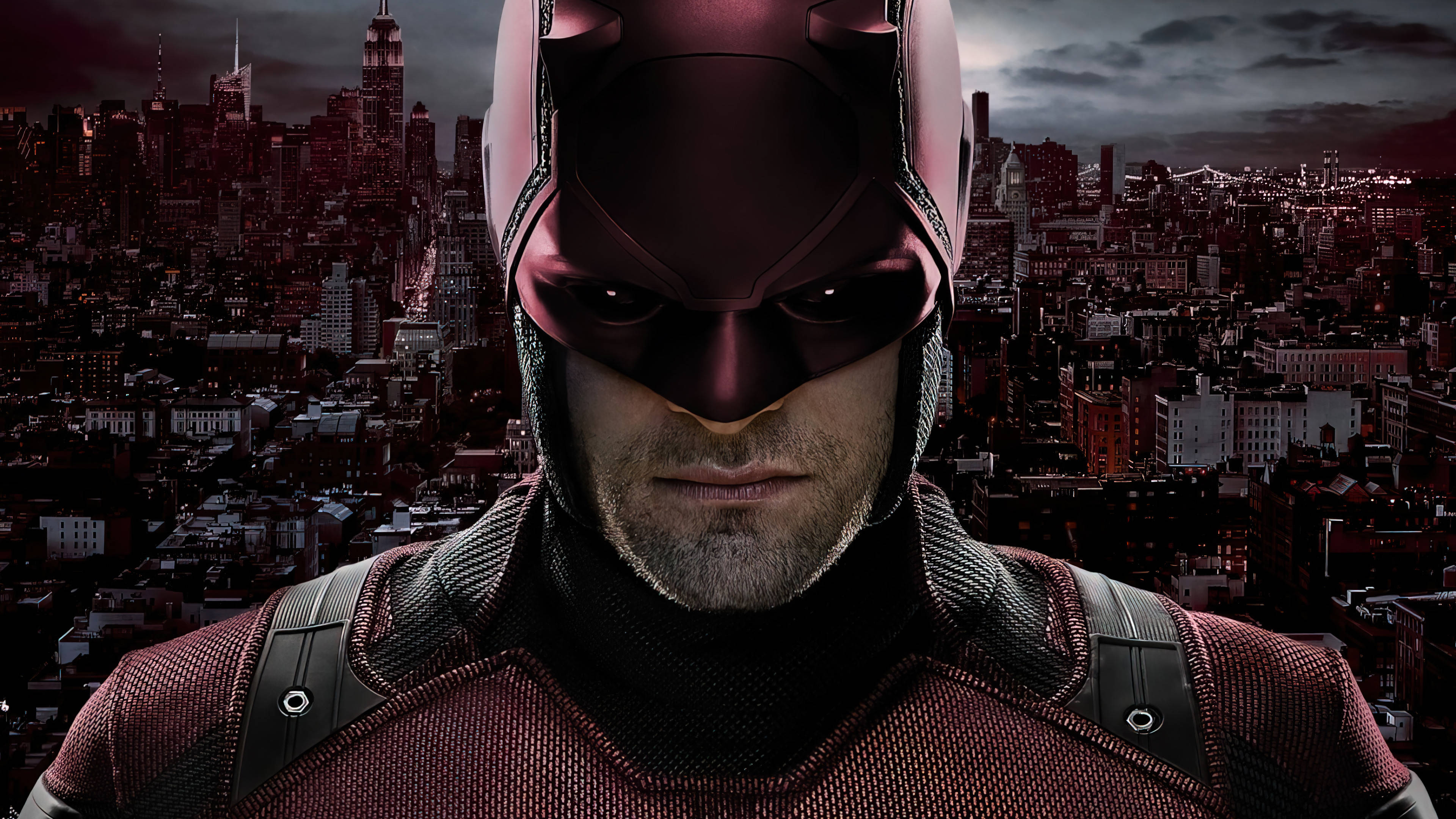 Marvel Superheroes 桌布 壁紙 — 夜間，夜魔俠身穿紅色戰衣，以黑暗的城市天際線為背景的特寫鏡頭。