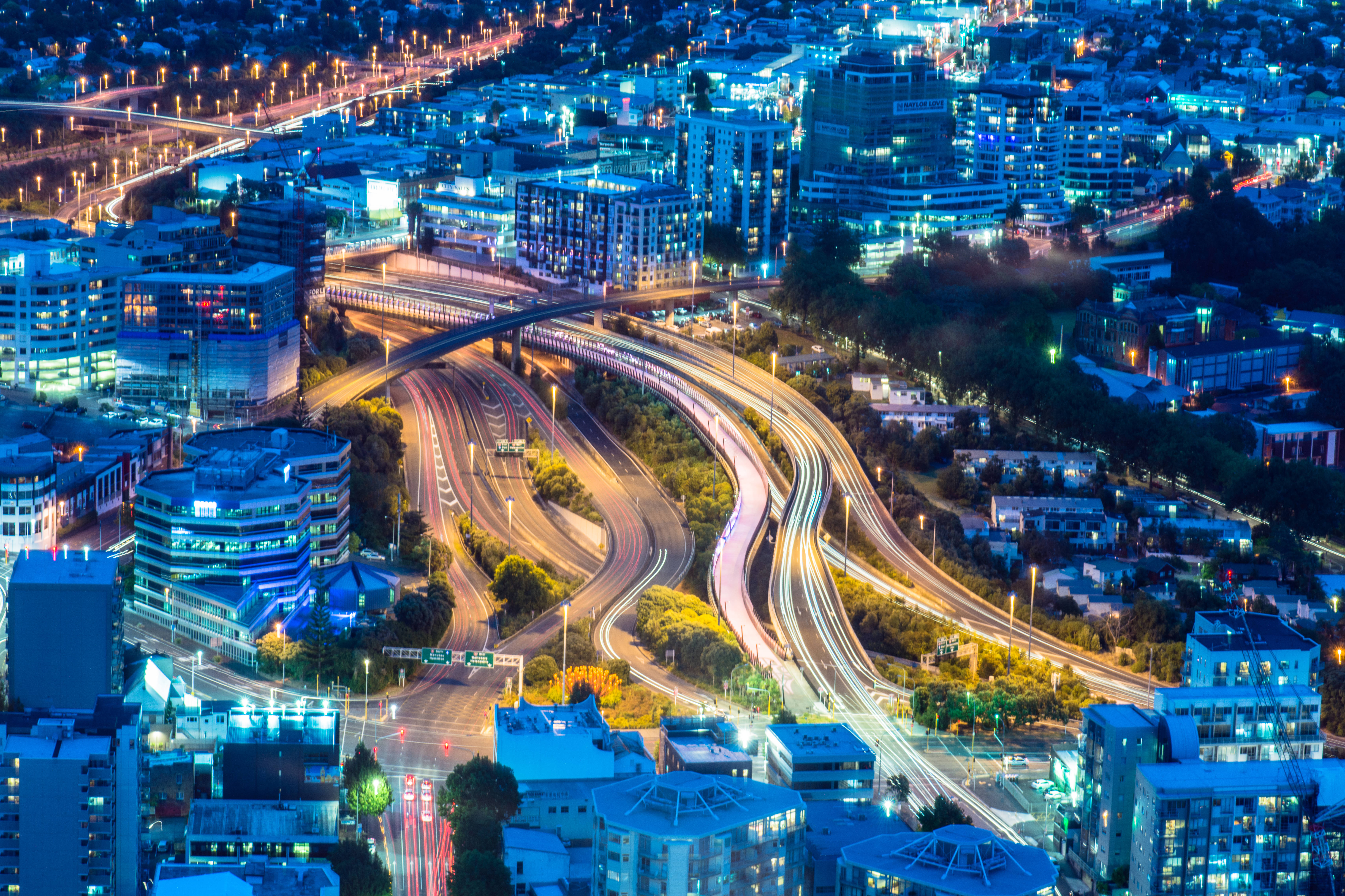 Screensavers 桌布 壁紙 — 夜間充滿活力的城市鳥瞰圖，有發光的高速公路和燈火通明的建築物。