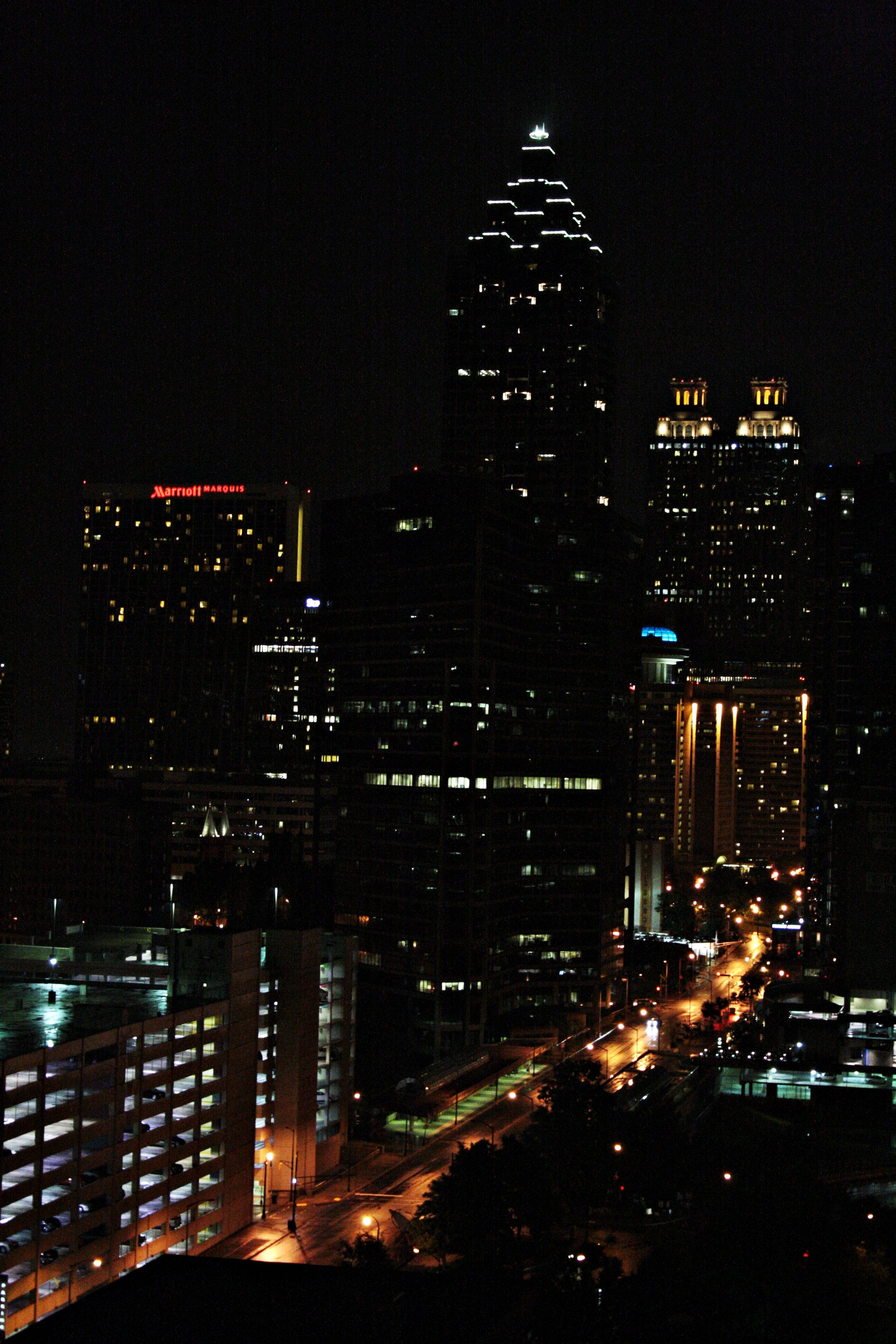 Atlanta Skyline 桌布 壁紙 — 夜間城市景觀，摩天大樓燈火通明，街燈閃爍，襯托著黑暗的天空。