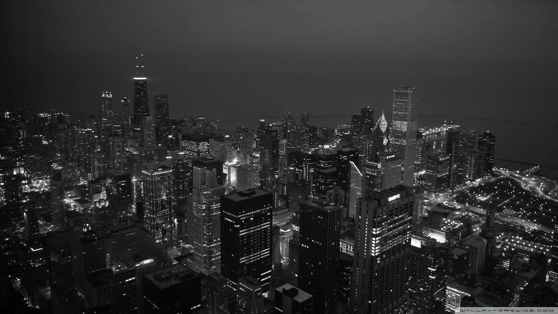 Aesthetic Black And White 桌布 壁紙 — 夜間廣闊城市景觀的單色空拍圖，無數高樓大廈和街道燈火通明。