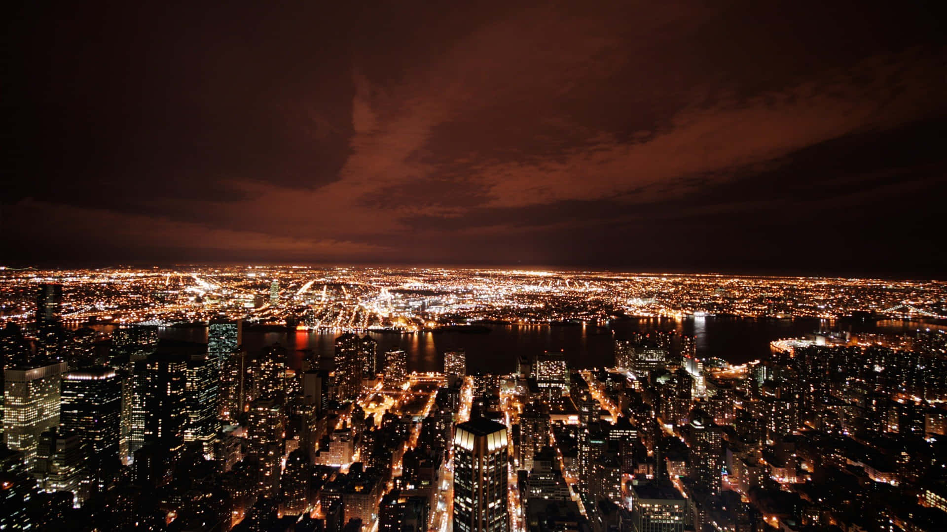 Nyc 桌布 壁紙 — 夜間廣闊城市的鳥瞰圖，發光的摩天大樓和黑暗的天空。