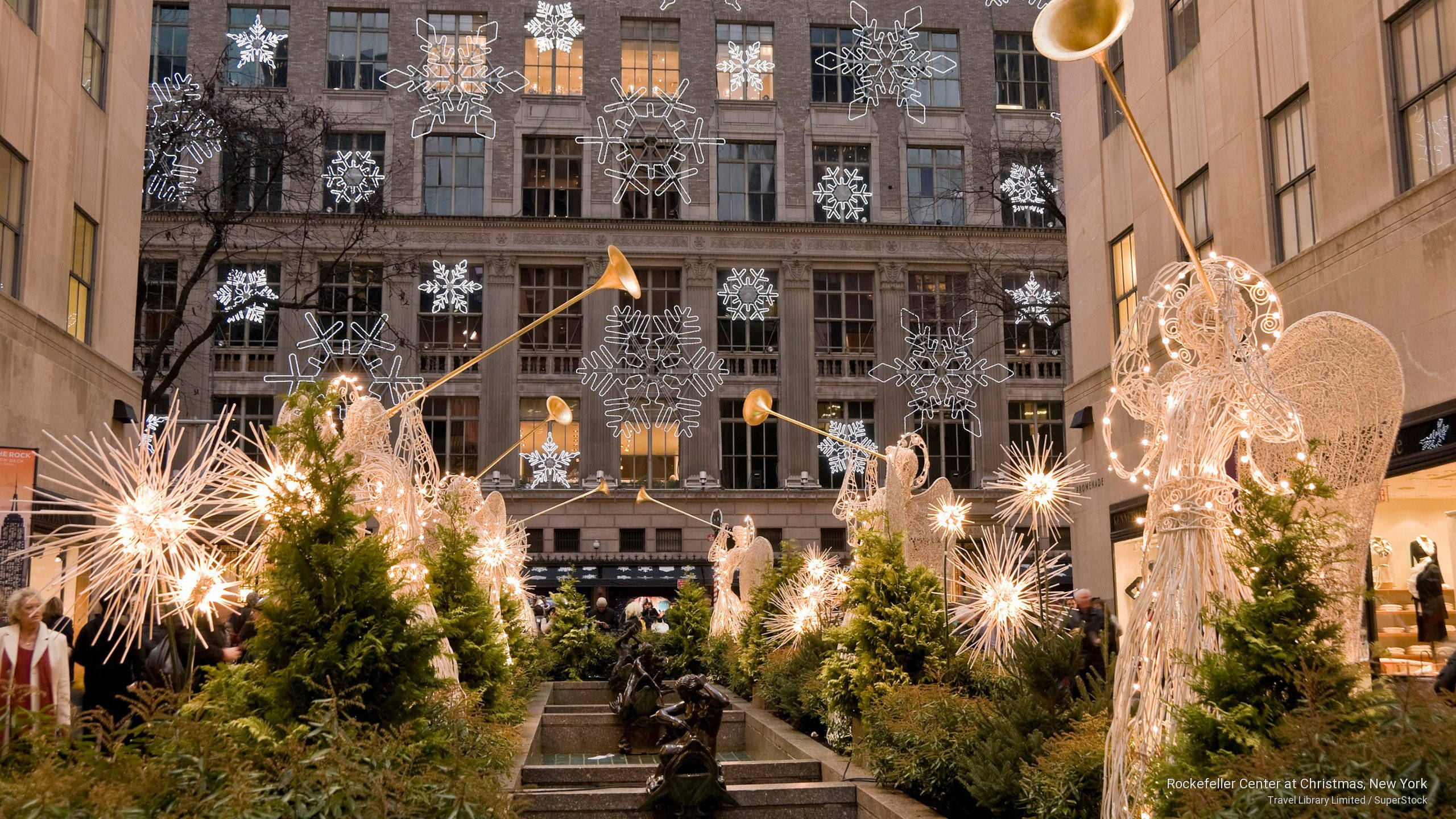 聖誕節 桌布 壁紙 — 夜間歷史建築外牆前，裝飾著發光天使雕塑和雪花燈的宏偉城市廣場。