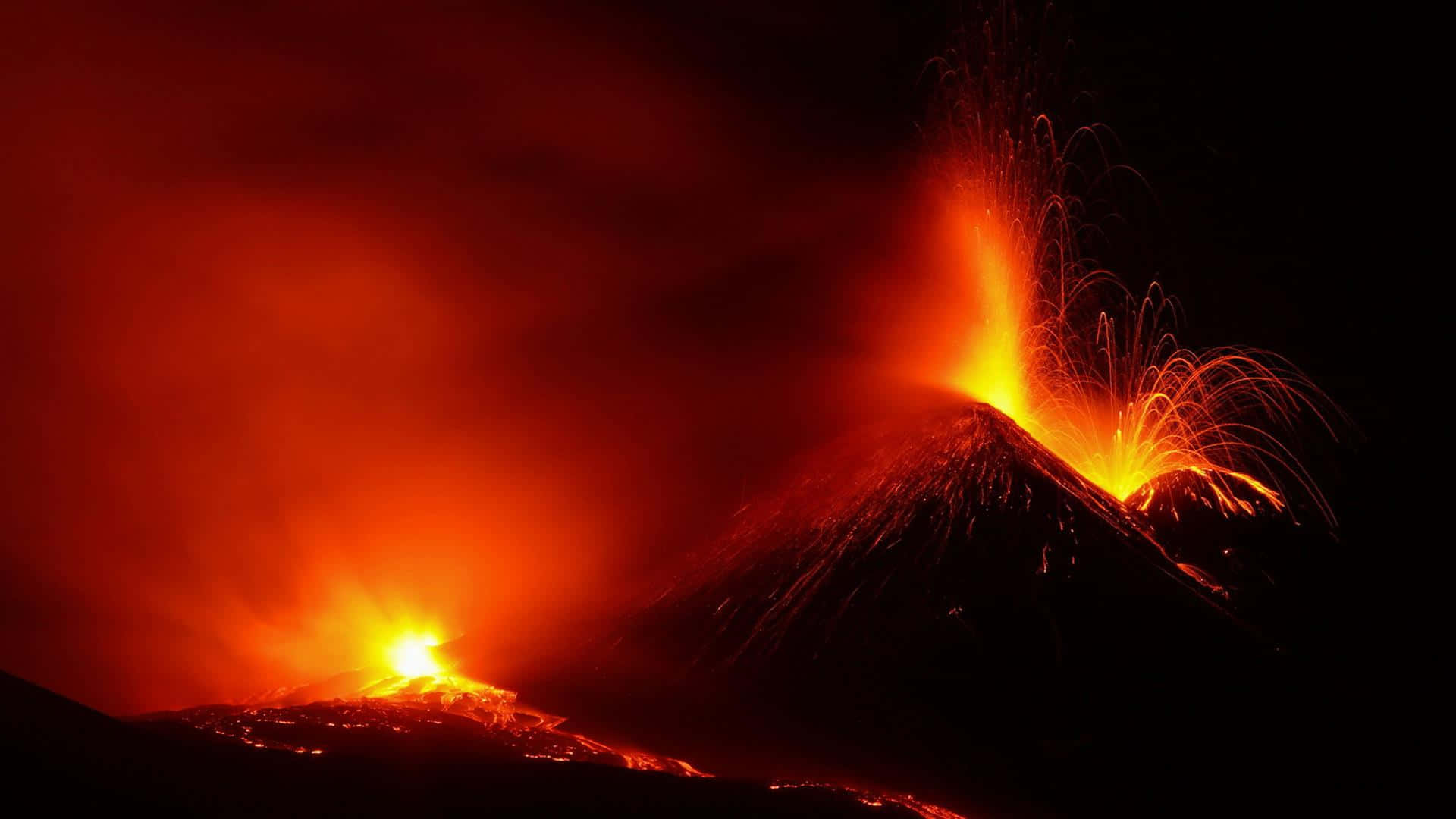 Volcano 桌布 壁紙 — 夜間火山爆發，熾熱的熔岩爆發和發光的紅橙色熔岩流照亮了黑暗的景觀。