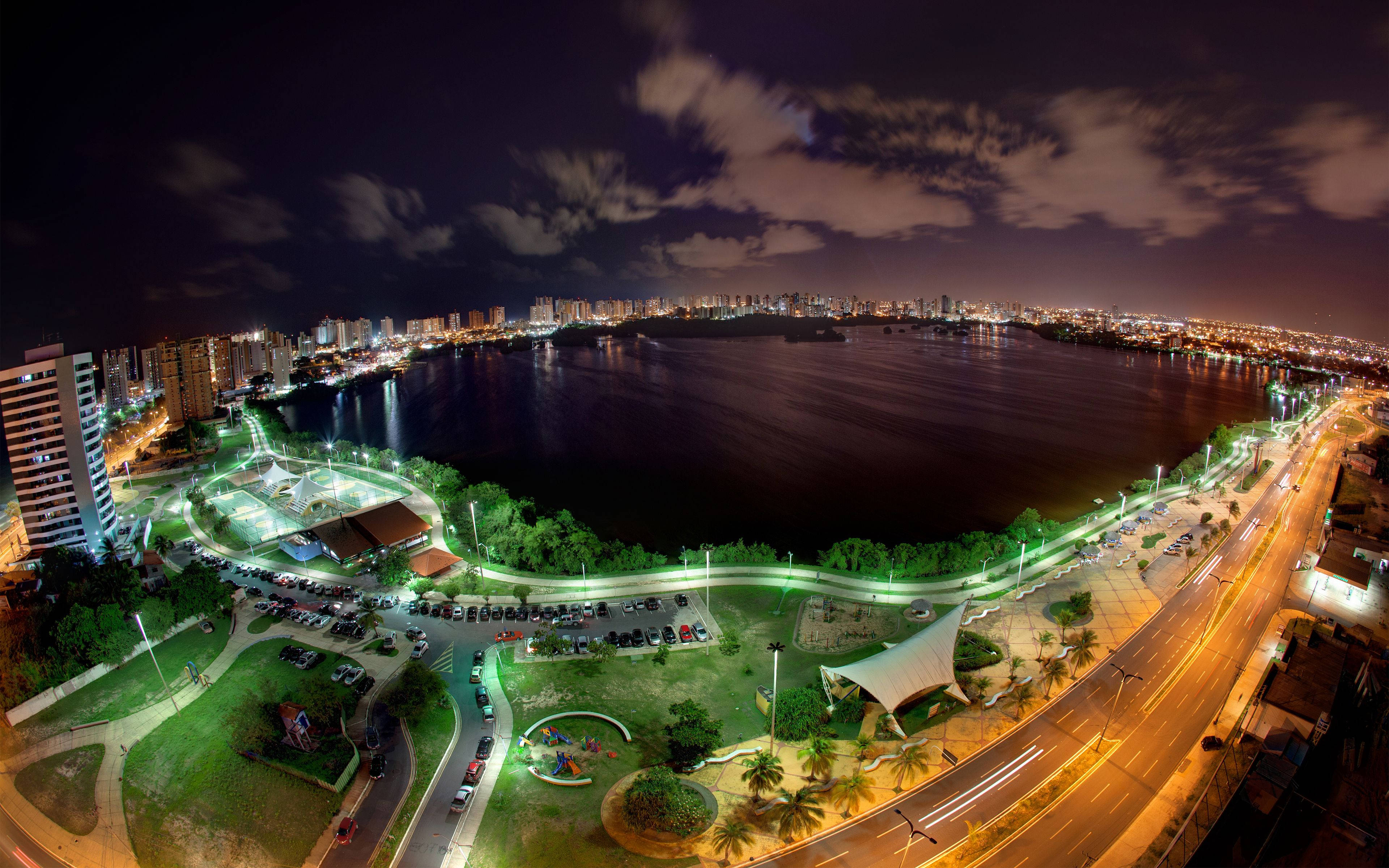 巴西 桌布 壁紙 — 夜間鳥瞰城市景觀，一個發光的湖泊被照亮公園和道路環繞，天空多雲。