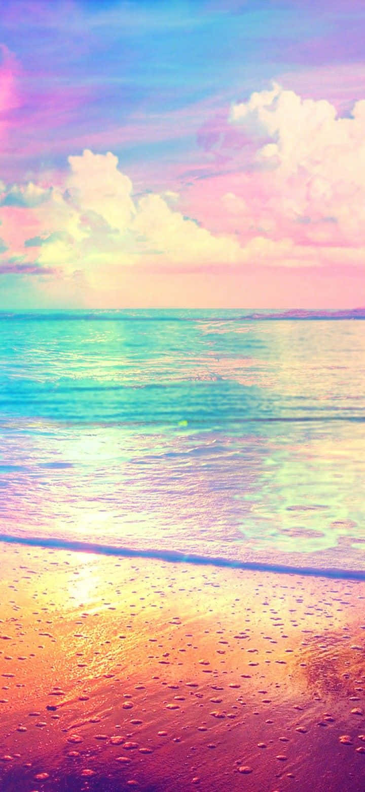 Pastel Beach 桌布 壁紙 — 夢幻海灘場景，粉彩粉紅和藍色天空倒映在碧綠海水和濕潤的金色沙灘上。