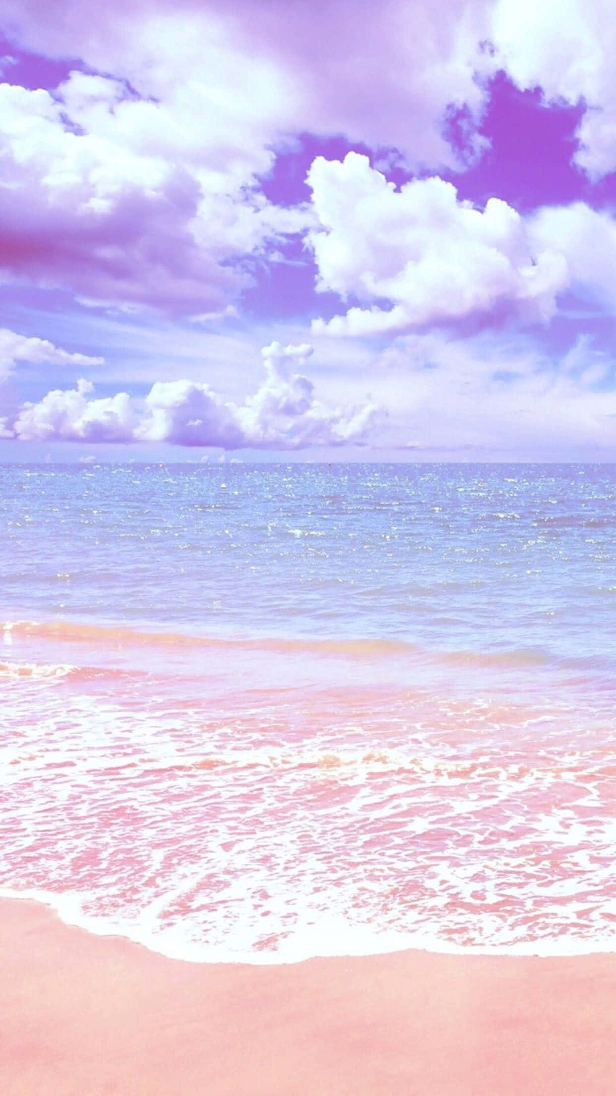 桌布 壁紙 — 夢幻海灘場景，粉紅色沙灘、溫柔海浪，天空點綴著柔和的紫色和白色雲彩。