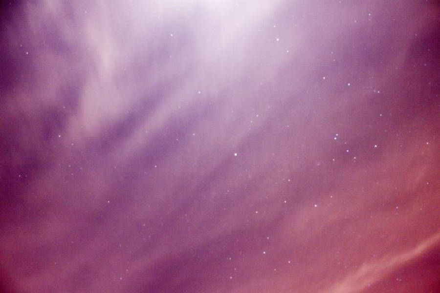 紫色夜空 桌布 壁紙 — 夢幻的夜空，以柔和的紫色和粉紅色繪成，零星的星星在薄雲之間閃爍。