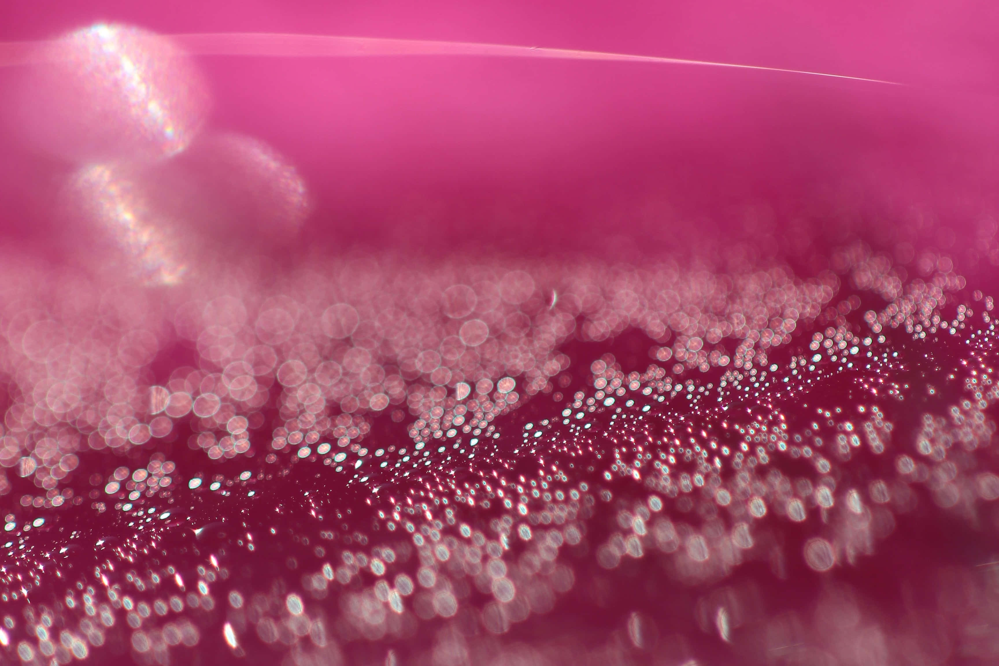 Glitter Pink 桌布 壁紙 — 夢幻粉紅色抽象背景，帶有閃爍的散景燈光和柔和發光球體，營造出神奇的閃爍效果。