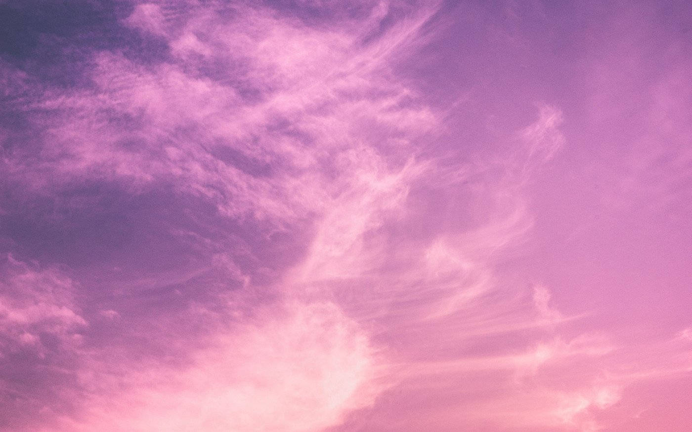 Pink Clouds 桌布 壁紙 — 夢幻般的天空，塗上柔和的粉紅色和紫色色調，帶有在日落時發光的縷縷雲彩。