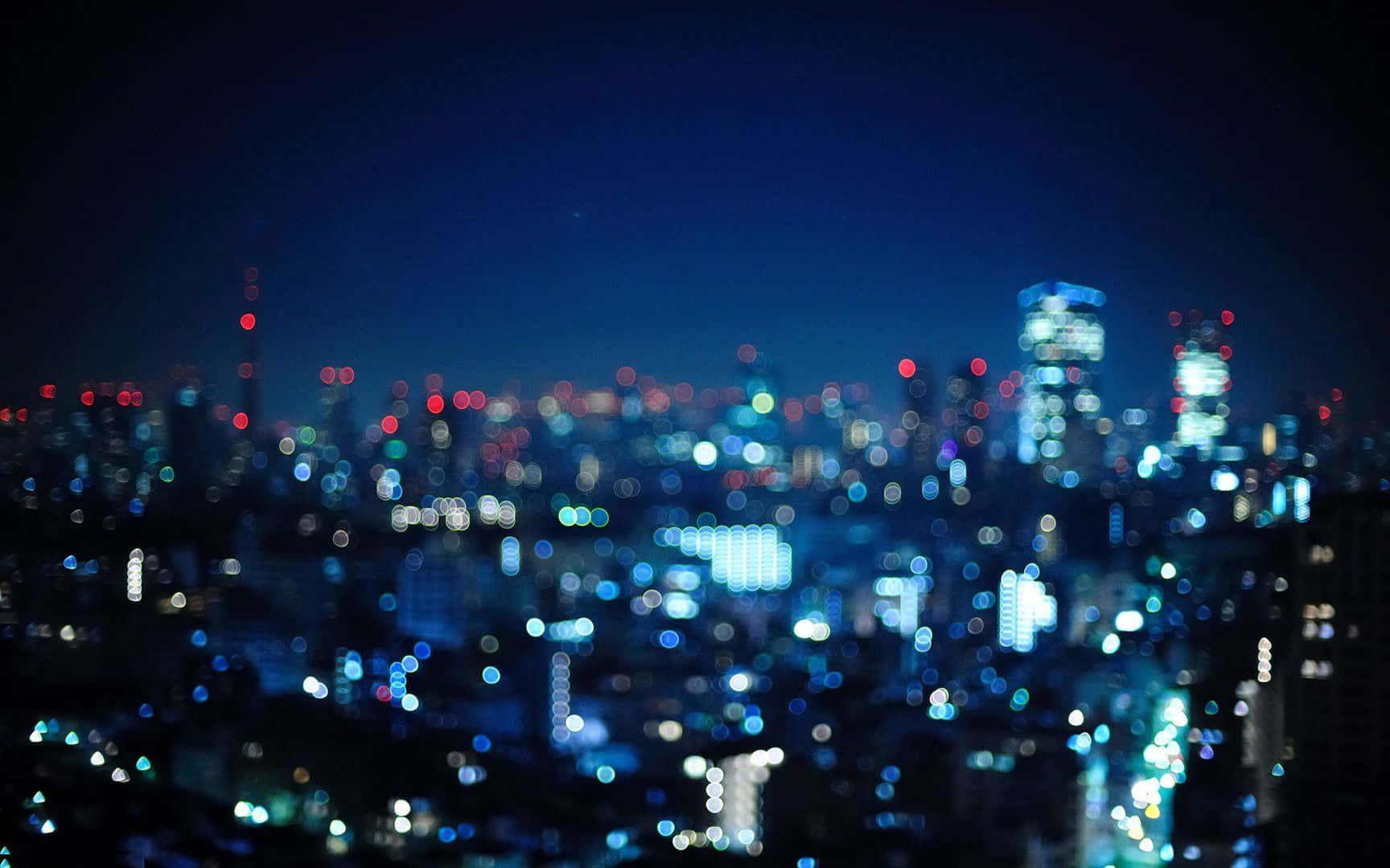 背景 桌布 壁紙 — 夢幻般的散景城市夜景，藍色、白色和紅色的燈光在黑暗的天空中閃爍。