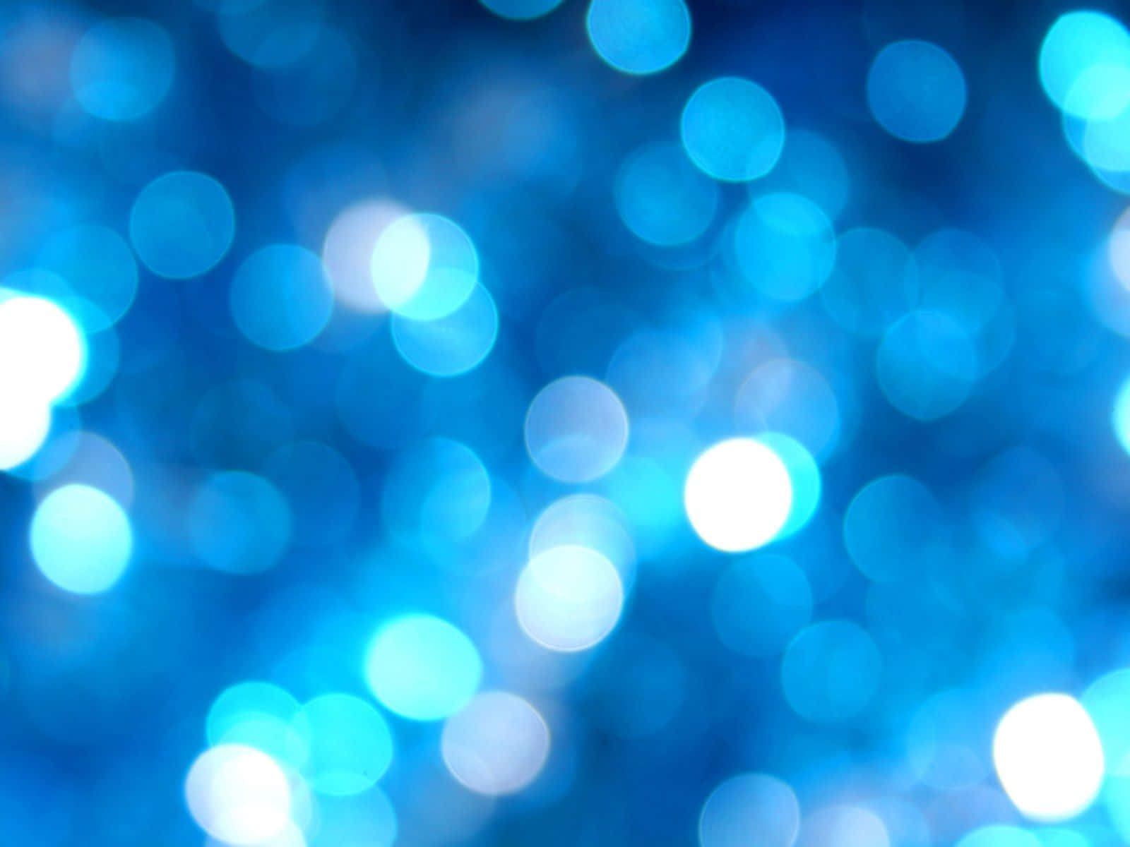 Blue Light Effects 桌布 壁紙 — 夢幻般的發光藍色散景燈光，在深藍色背景上柔和模糊。