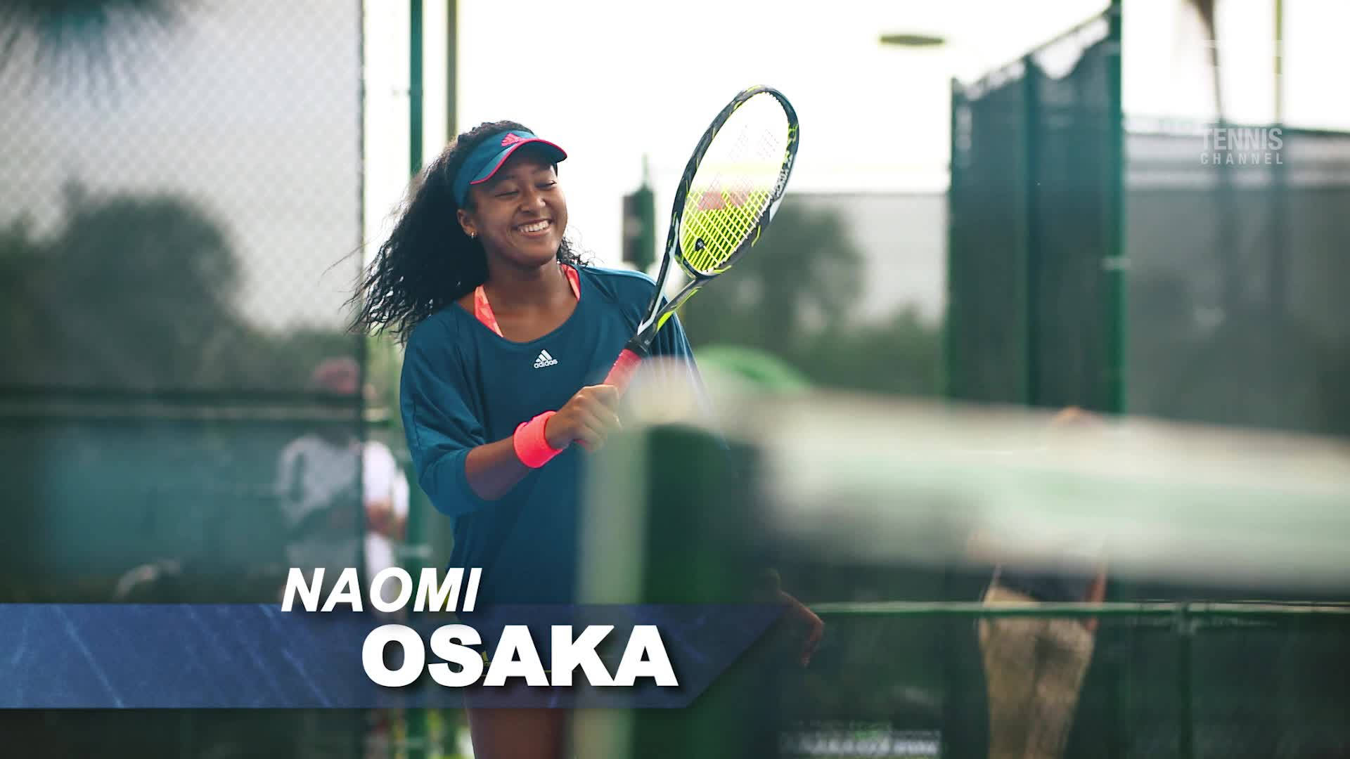 naomi 桌布 壁紙 — 大坂直美在陽光明媚的網球場上揮拍時燦爛微笑，球拍帶有動態模糊效果。