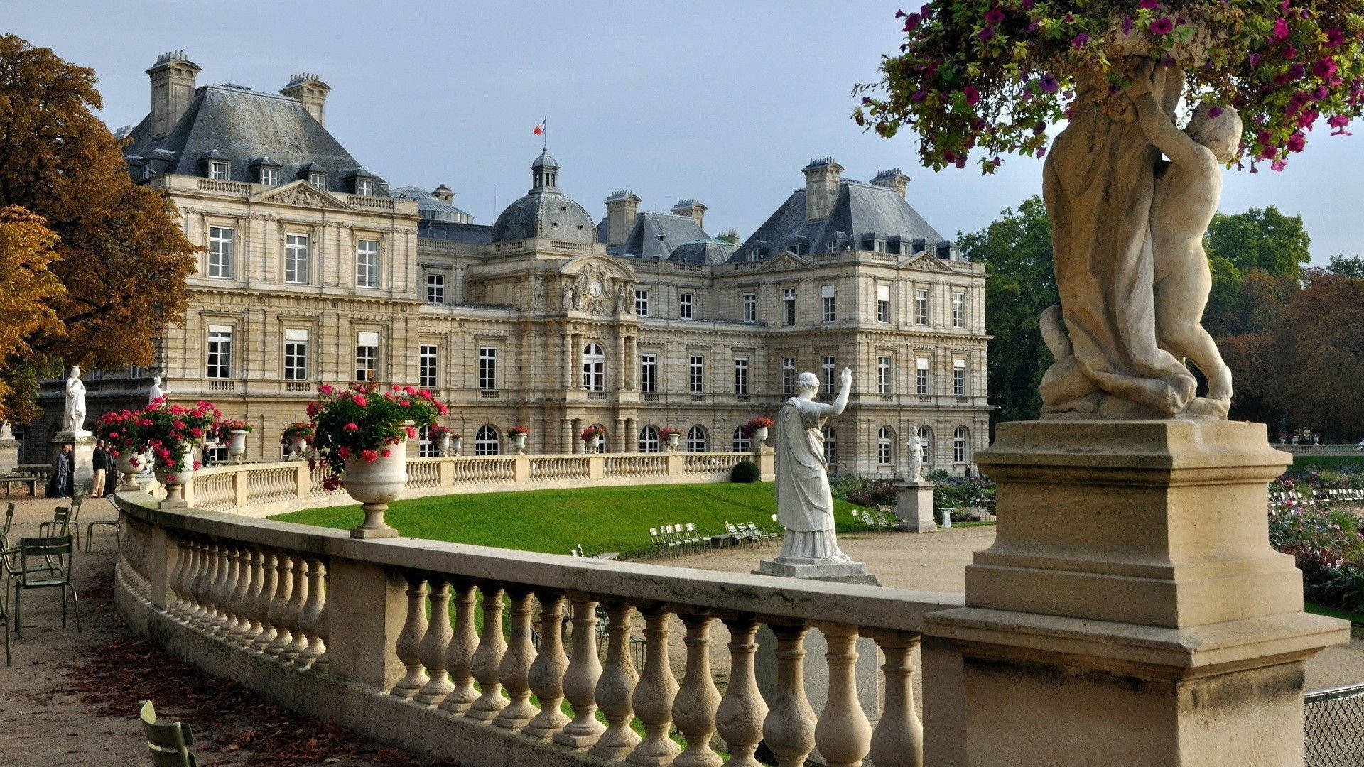 Luxembourg 桌布 壁紙 — 大型石砌豪宅，圓頂屋頂，雕像點綴，整齊花園，晴朗天空下。