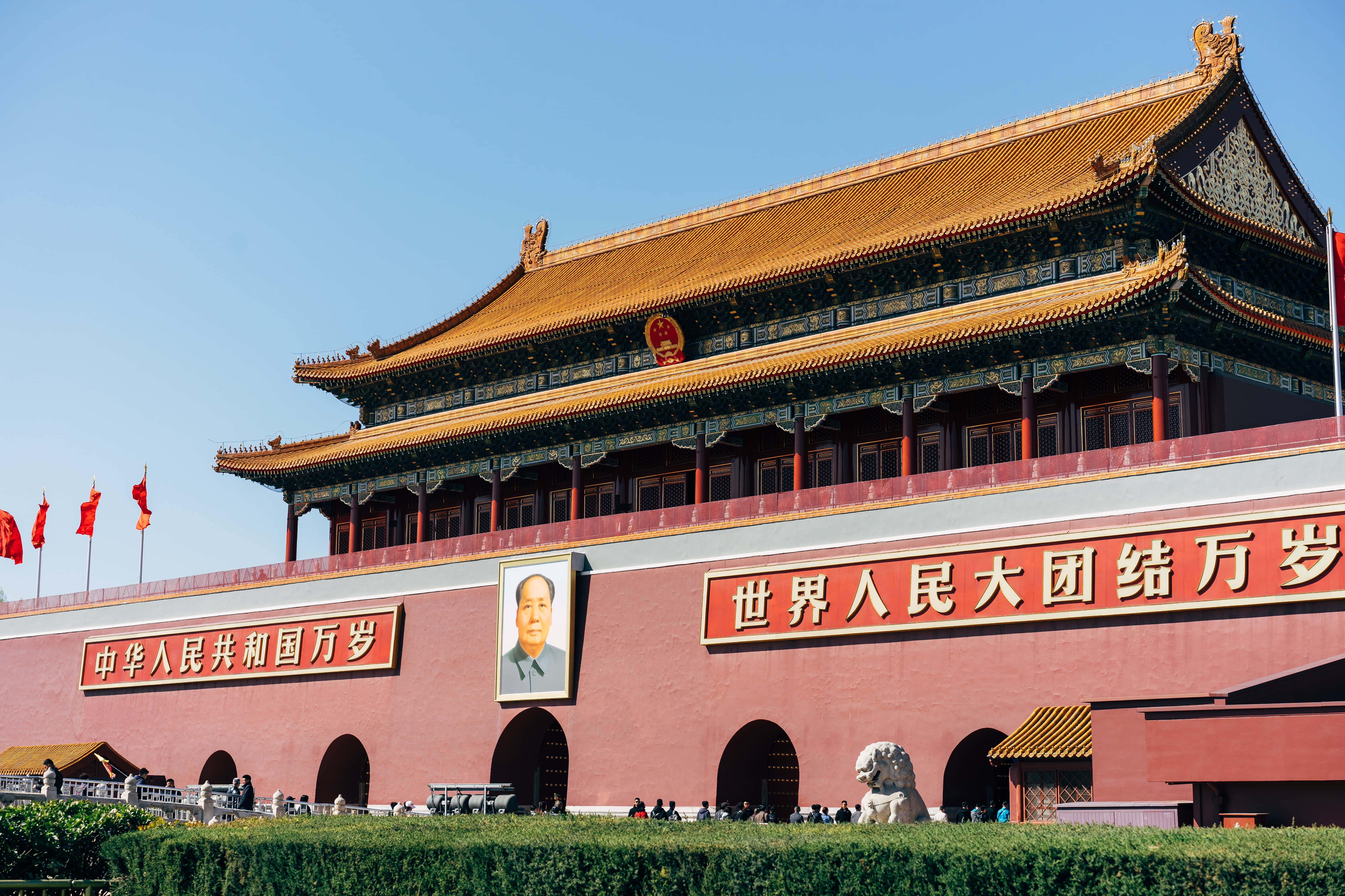Flag 桌布 壁紙 — 大型紅色大門，金色屋頂，毛澤東畫像，在晴朗藍天下，有紅色旗幟和石獅。