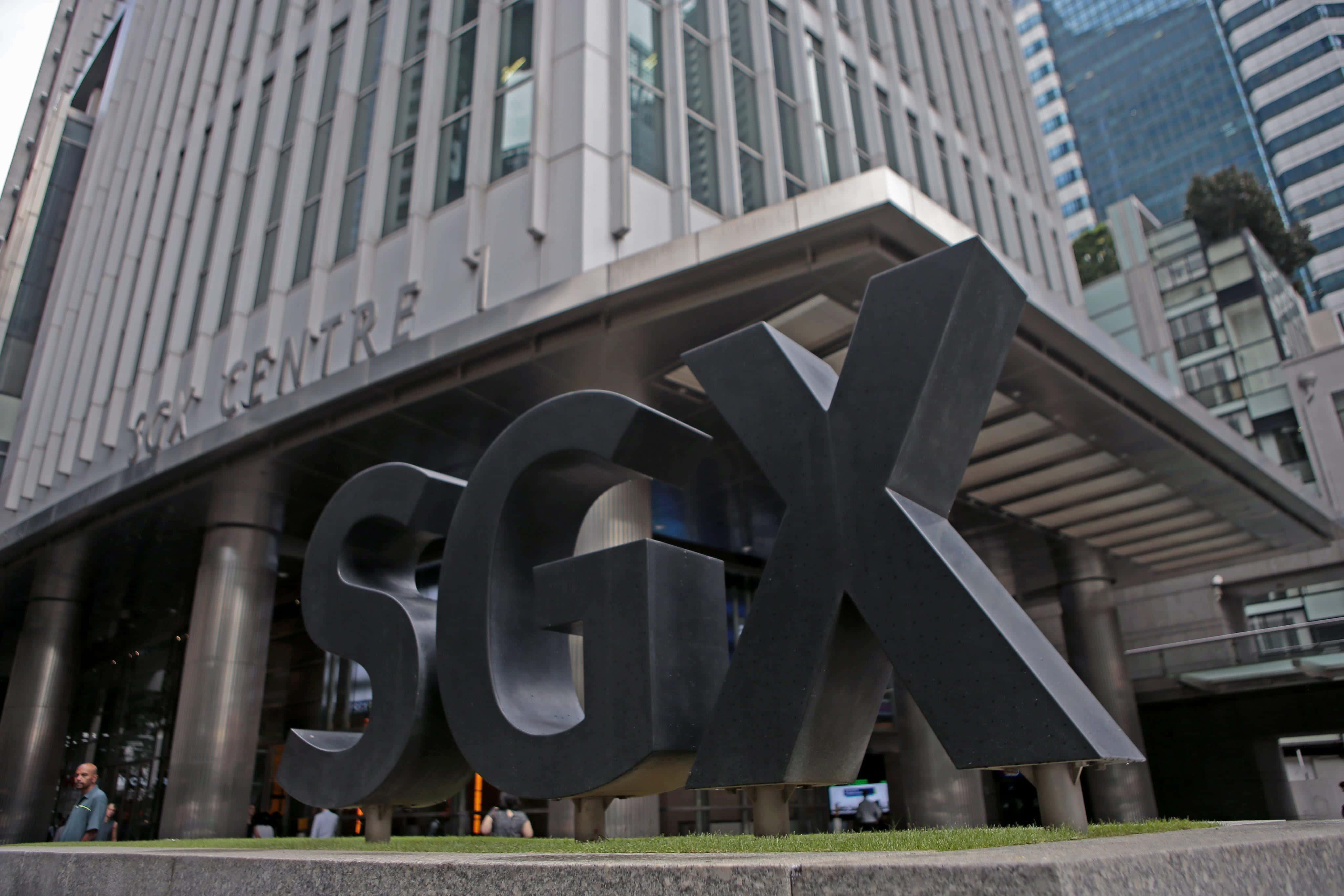 股票 桌布 壁紙 — 大型黑色SGX字母醒目地矗立在一座現代玻璃和鋼鐵摩天大樓前，附近有行人走過。