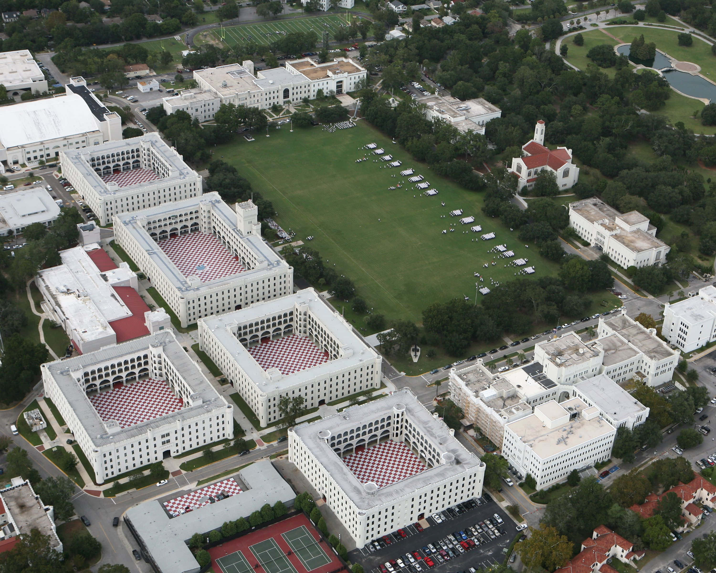 The Citadel 桌布 壁紙 — 大學校園的鳥瞰圖，白色建築環繞著一個大型綠色場地和一個紅頂教堂。