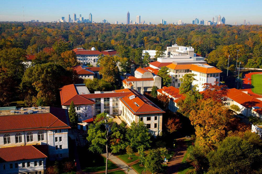 Buildings 桌布 壁紙 — 大學校園的鳥瞰圖，紅頂建築坐落在秋樹之中，遠處可見城市天際線。
