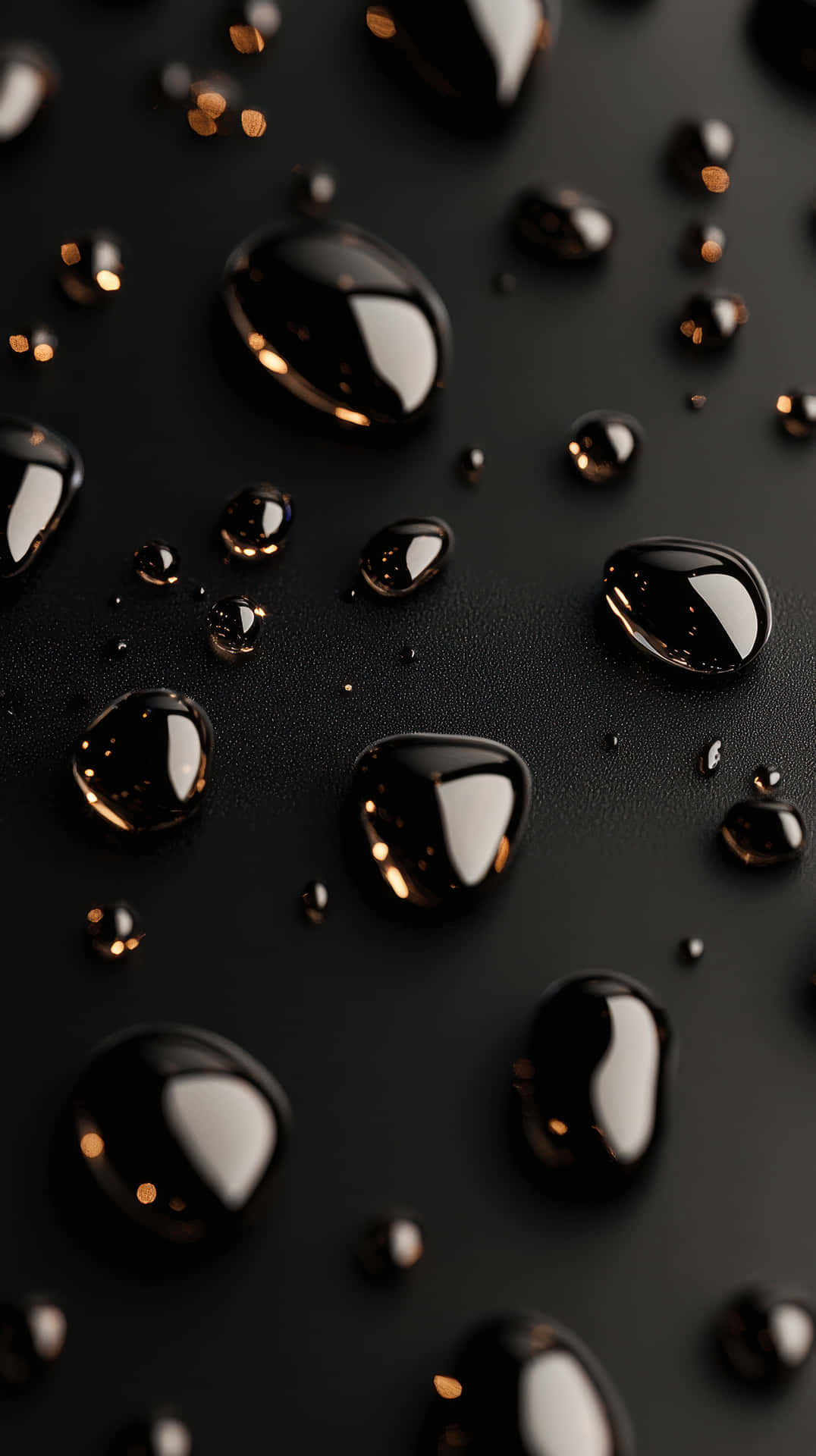 Black Water Droplets on a Smooth Dark Surface with Light Reflections 壁紙 — 大小不一的閃爍水滴停留在啞黑色表面，反射溫暖的金色光線。