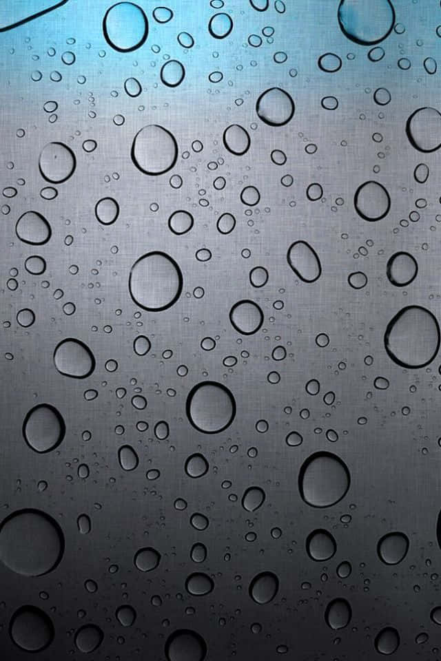 iOS 4 桌布 壁紙 — 大小不一的雨滴依附在帶有紋理的金屬表面上，在冷藍色燈光下。