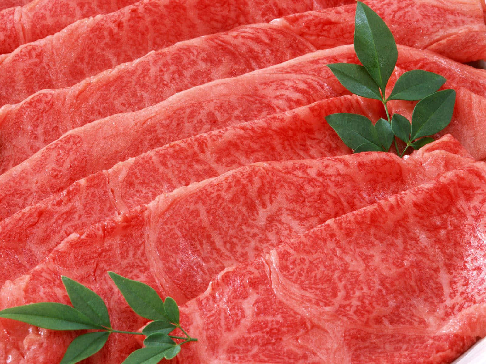 Red Meat 桌布 壁紙 — 大理石紋牛肉片搭配綠葉，以特寫食物擺盤方式呈現。
