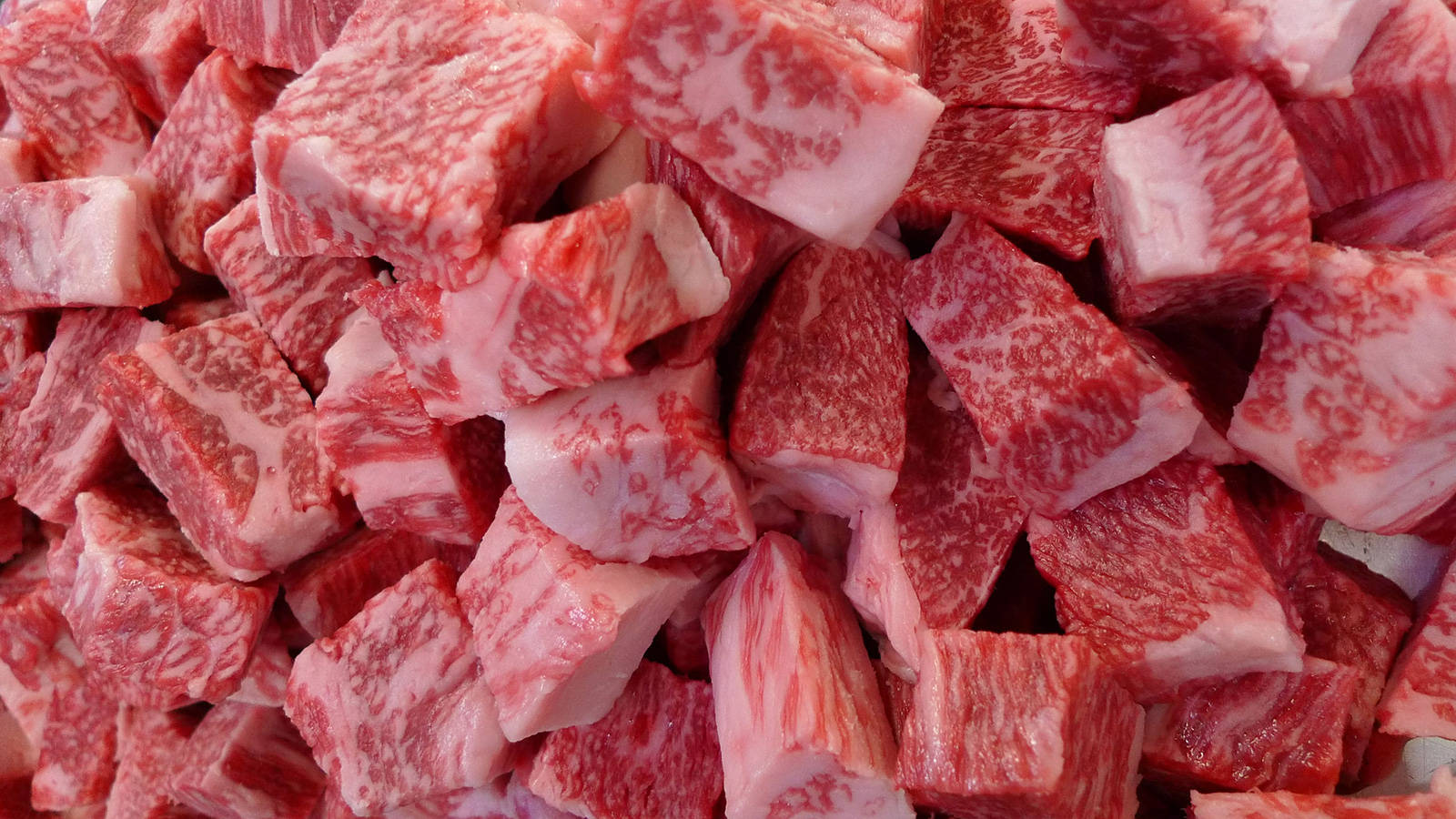 meat 桌布 壁紙 — 大理石紋生牛肉塊的特寫，展示豐富的紅肉和複雜的白色脂肪圖案。