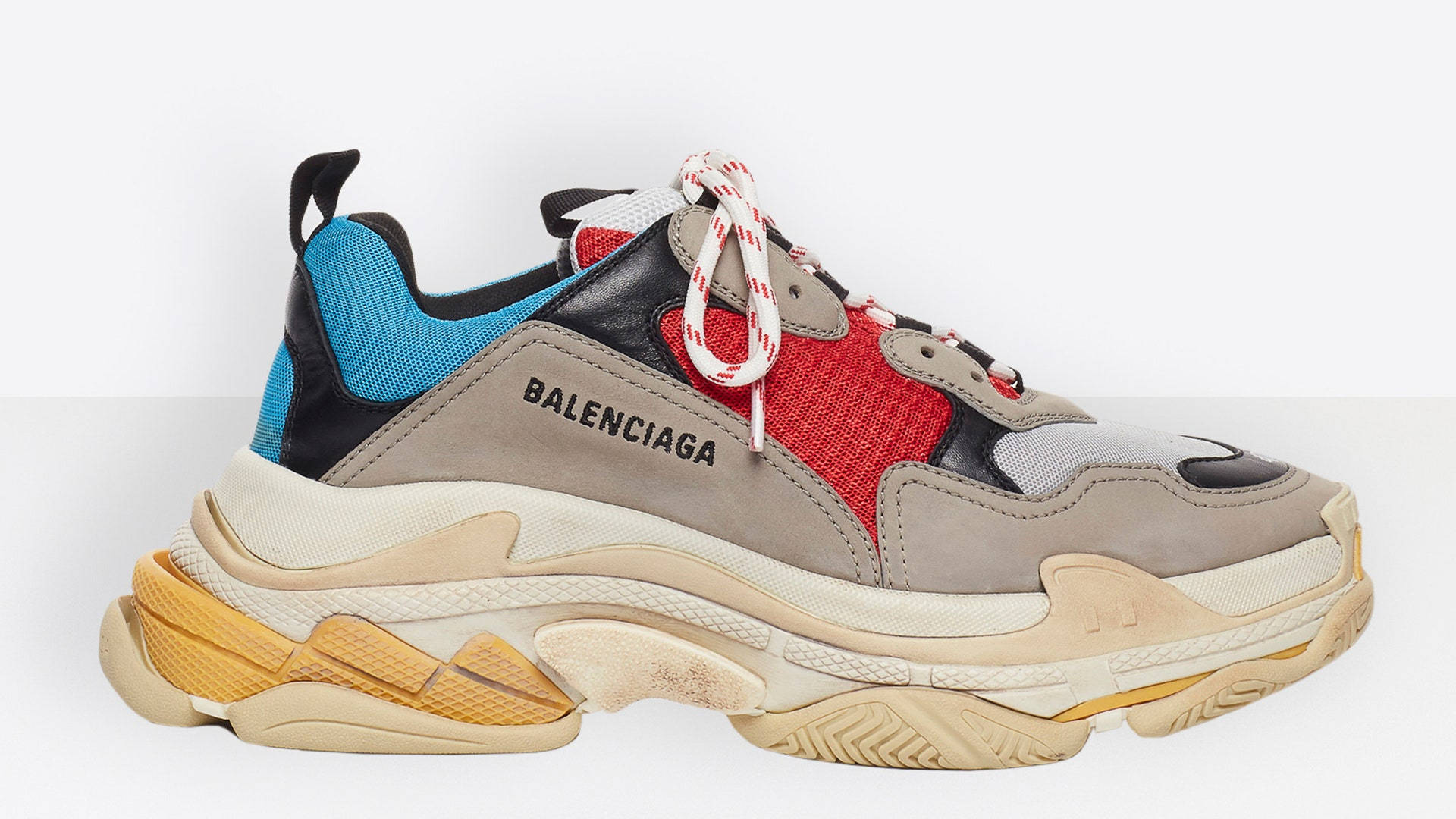Balenciaga 桌布 壁紙 — 大膽的 Balenciaga 運動鞋，厚米色鞋底，紅、藍、黑面板，白色鞋帶，純白背景。