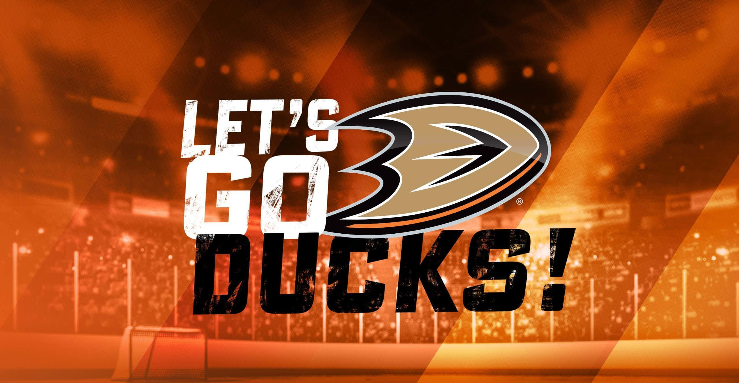 安納海姆鴨隊 桌布 壁紙 — 大膽的 'LET'S GO DUCKS!' 文字與球隊標誌主導了火焰橙色冰球場背景，配以模糊的場館燈光。