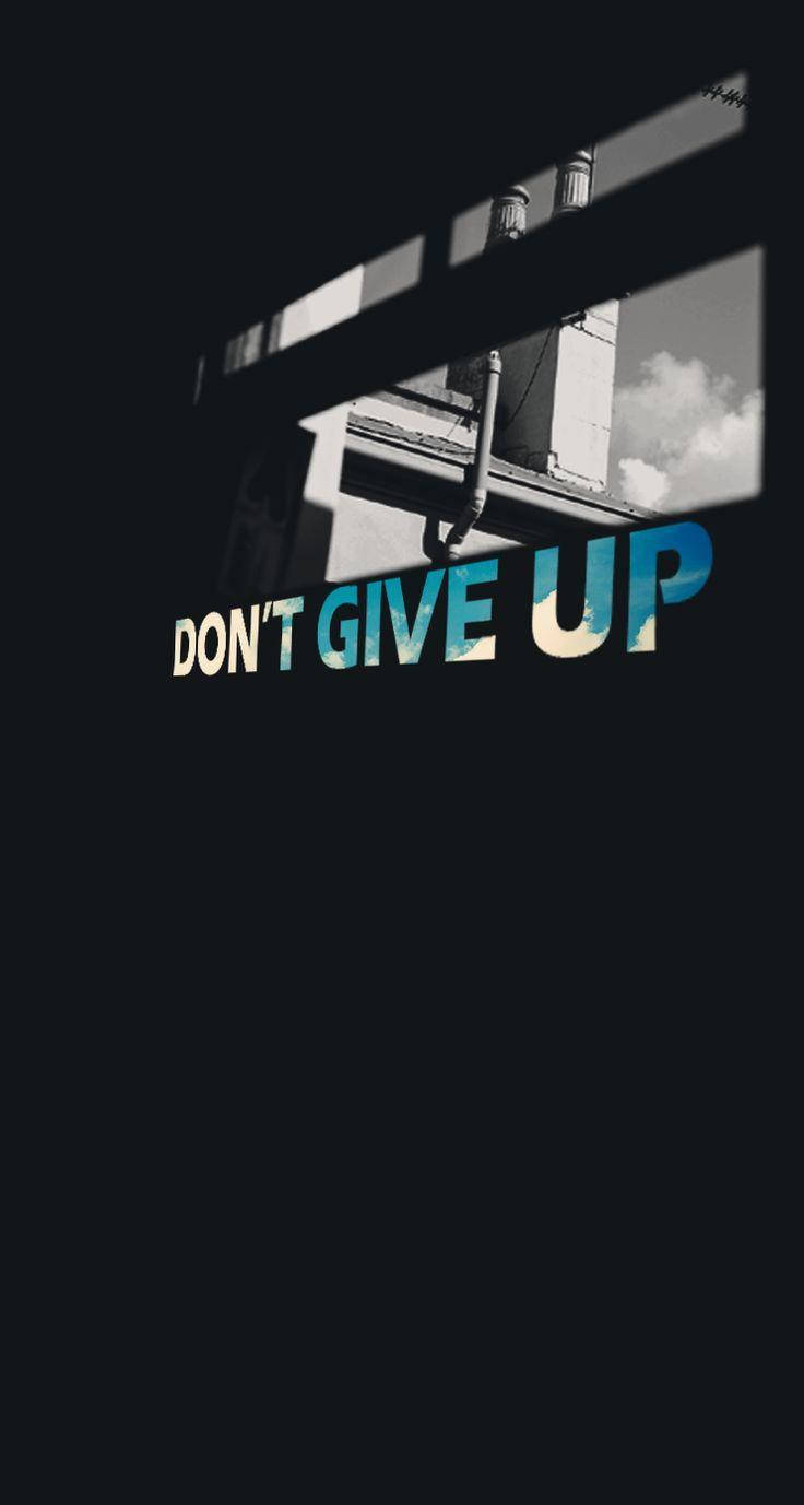 Give 桌布 壁紙 — 大膽的勵志文字「don't give up」穿過窗框，在黑暗的城市背景下閃耀。