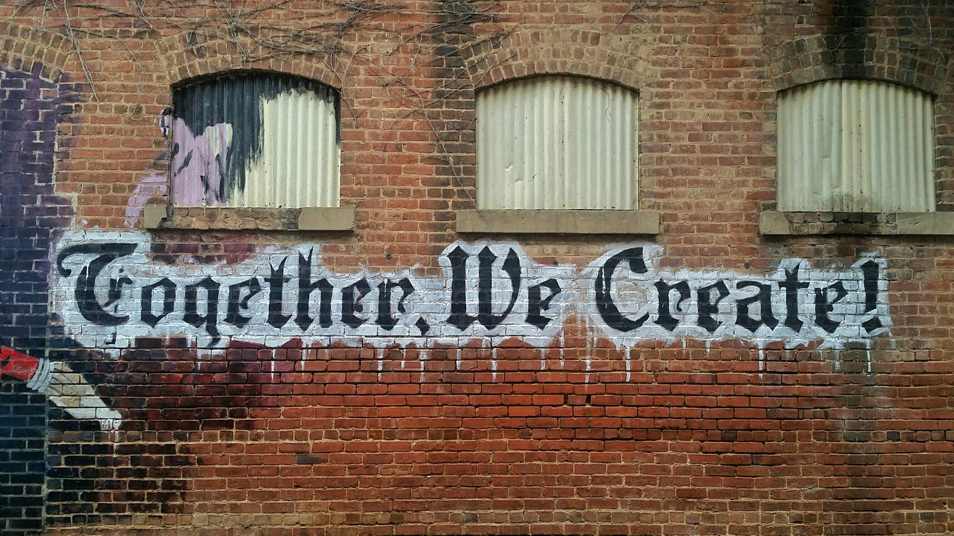 磚牆上的塗鴉壁畫，寫著 Together We Create — 字型 GIF 壁紙