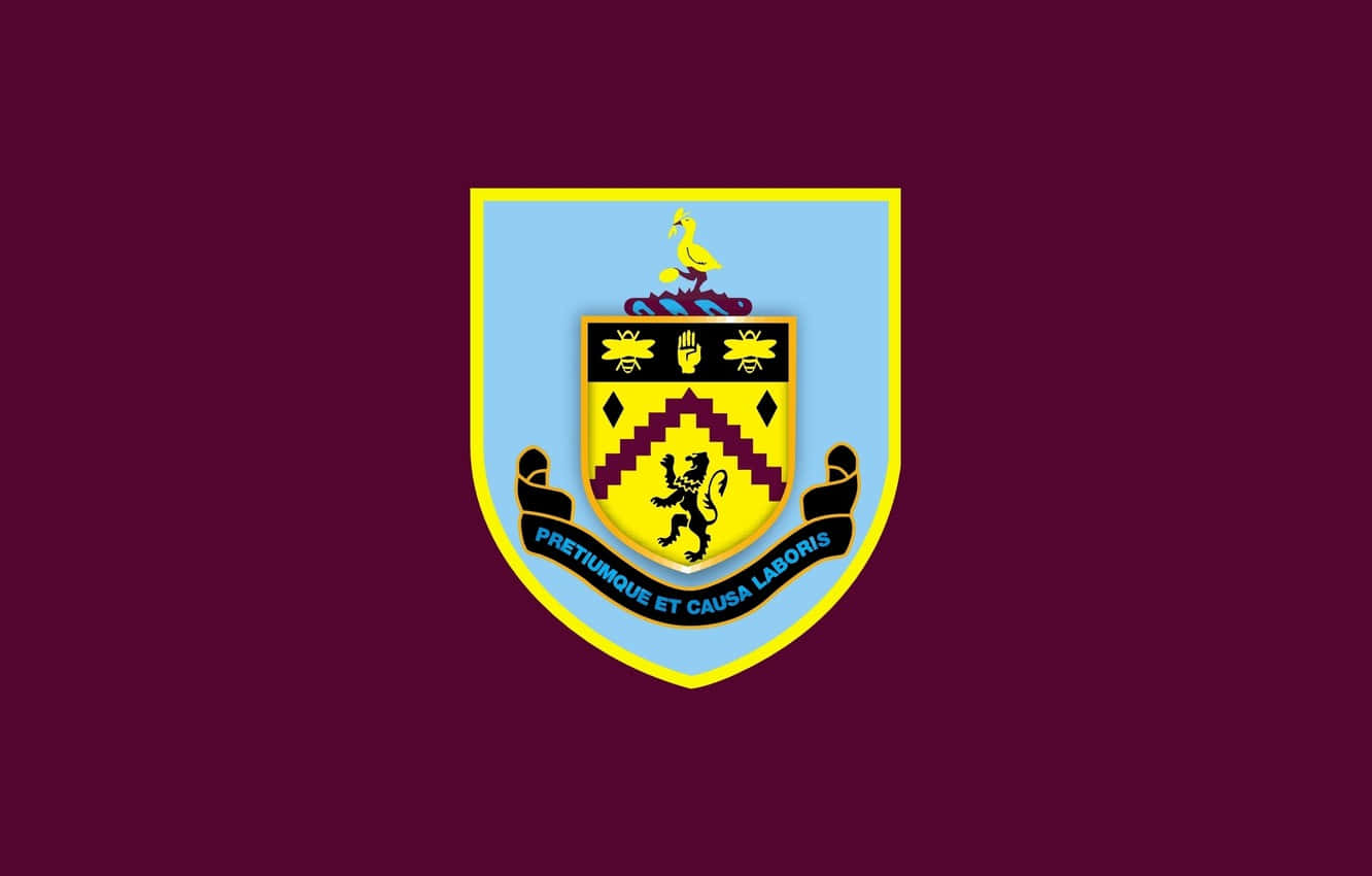 Burnley Fc 桌布 壁紙 — 大膽的栗色背景，中央有一個淺藍色盾牌，帶有黃色邊框，顯示一隻黑色直立獅子、蜜蜂和一句格言，頂部有一隻黃色鳥。