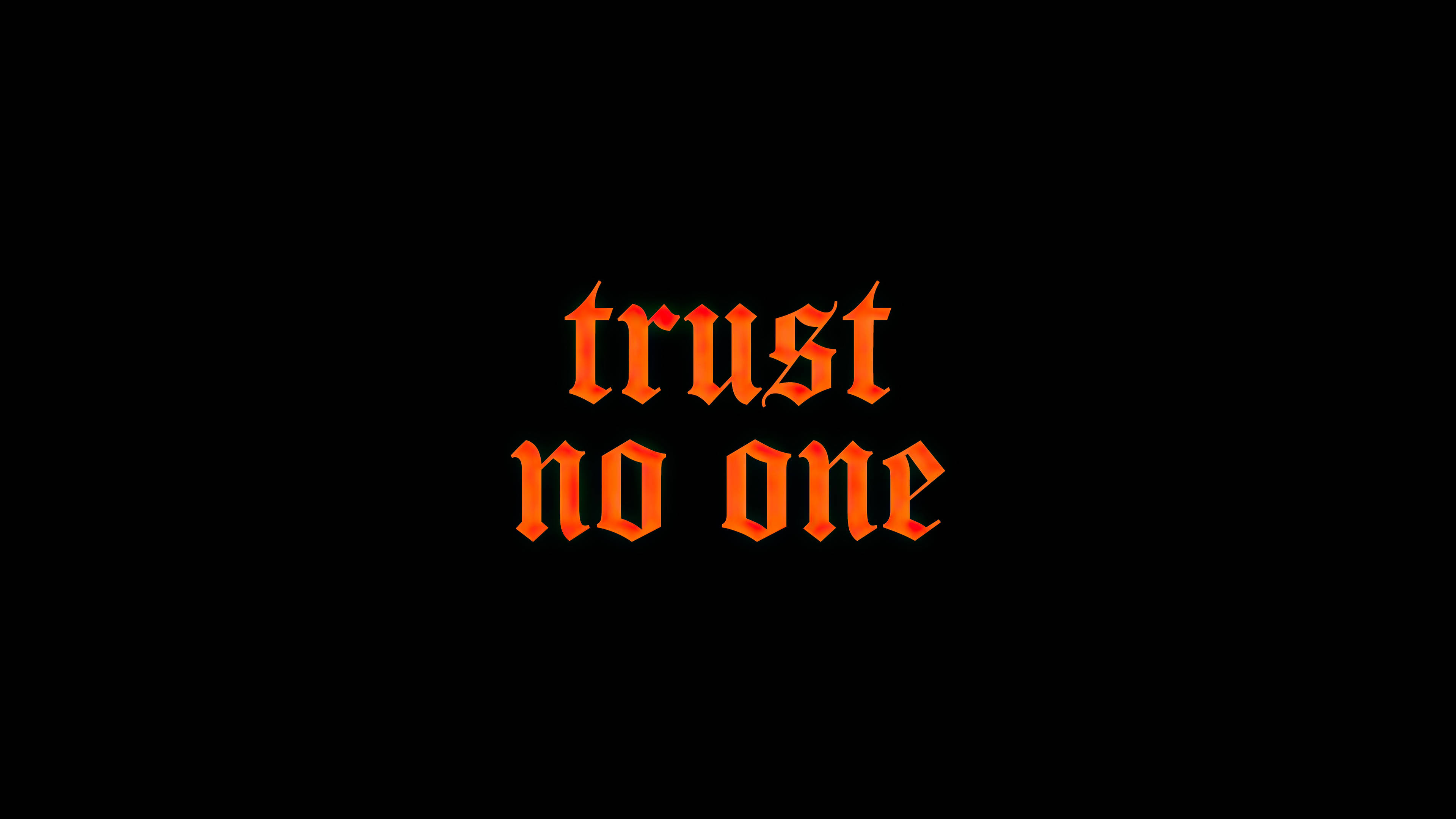 橘色 桌布 壁紙 — 大膽的橙色哥德式文字「trust no one」在純黑背景上發光。