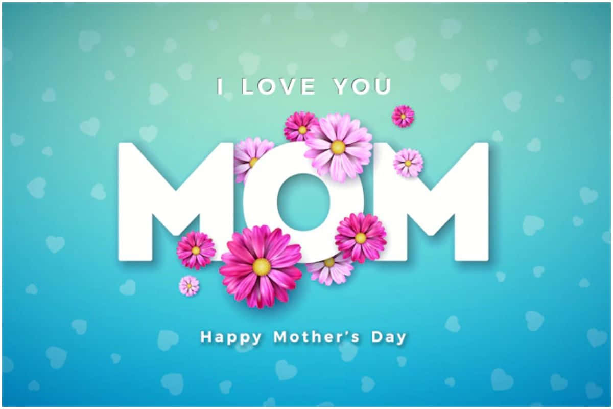 Mothers Day 桌布 壁紙 — 大膽的白色 'MOM' 文字，飾以粉紅色花朵，背景為柔和的藍色漸變，帶有微妙的愛心圖案。